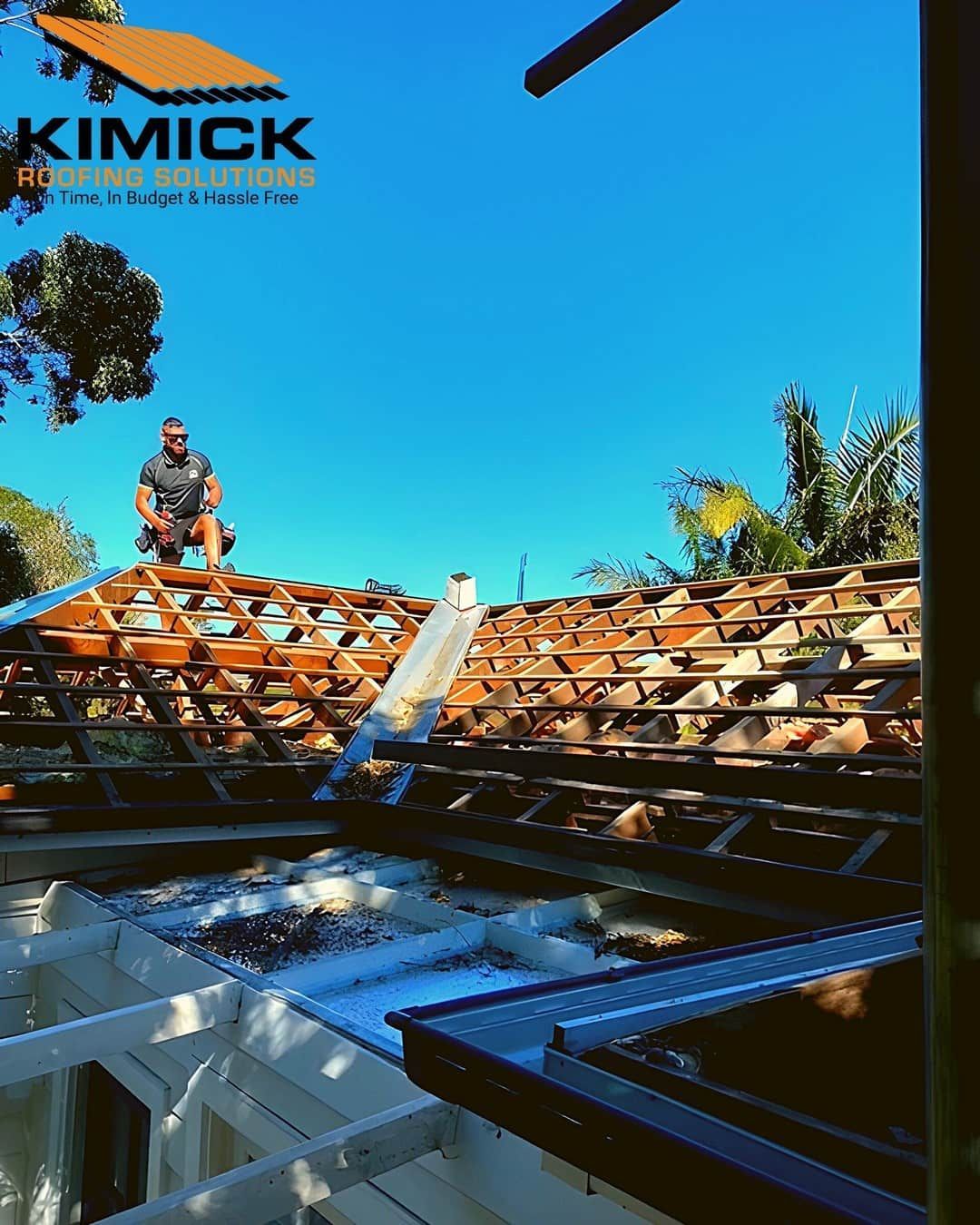 A Man Is Working On The Roof — Kimick Roofing Solutions In Fortitude Valley, QLD