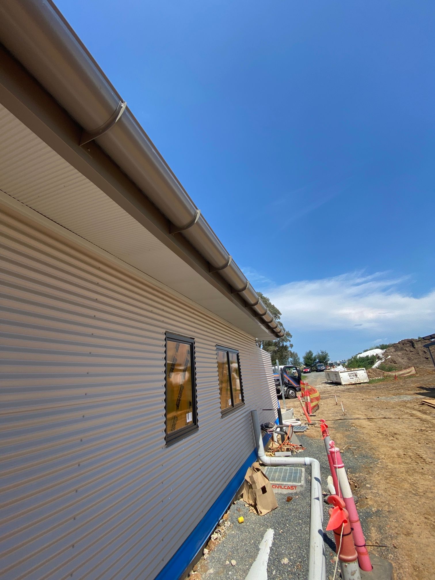 A house is being built in a field with a blue sky in the background — Kimick Roofing Solutions In Wyong, NSW