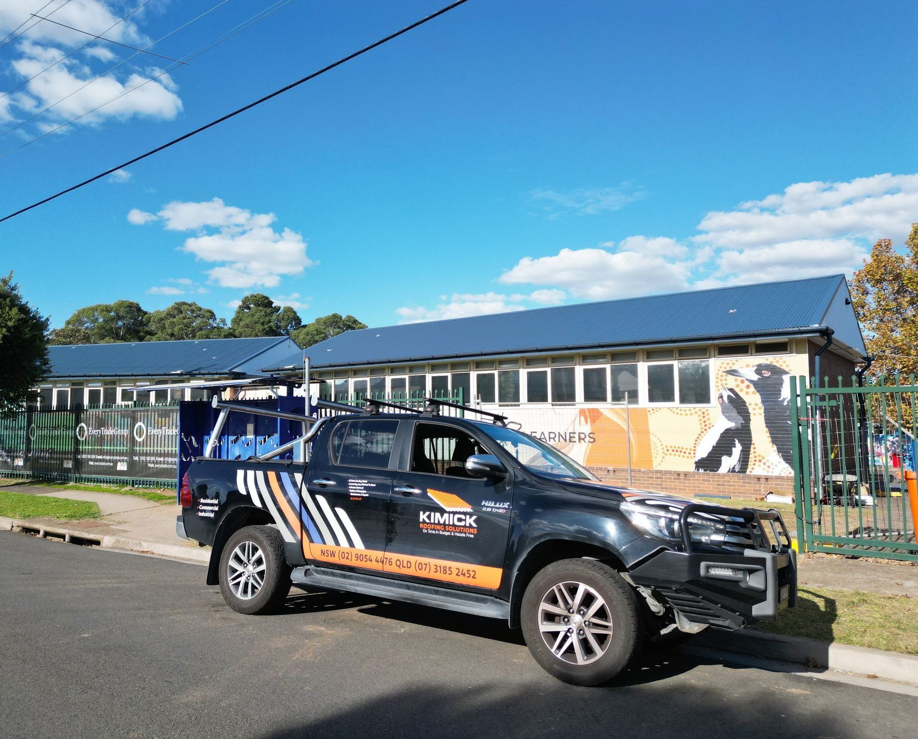 A Large Building With A Ute With The Words Kimick Roofing On It— Kimick Roofing Solutions In Fortitude Valley, QLD