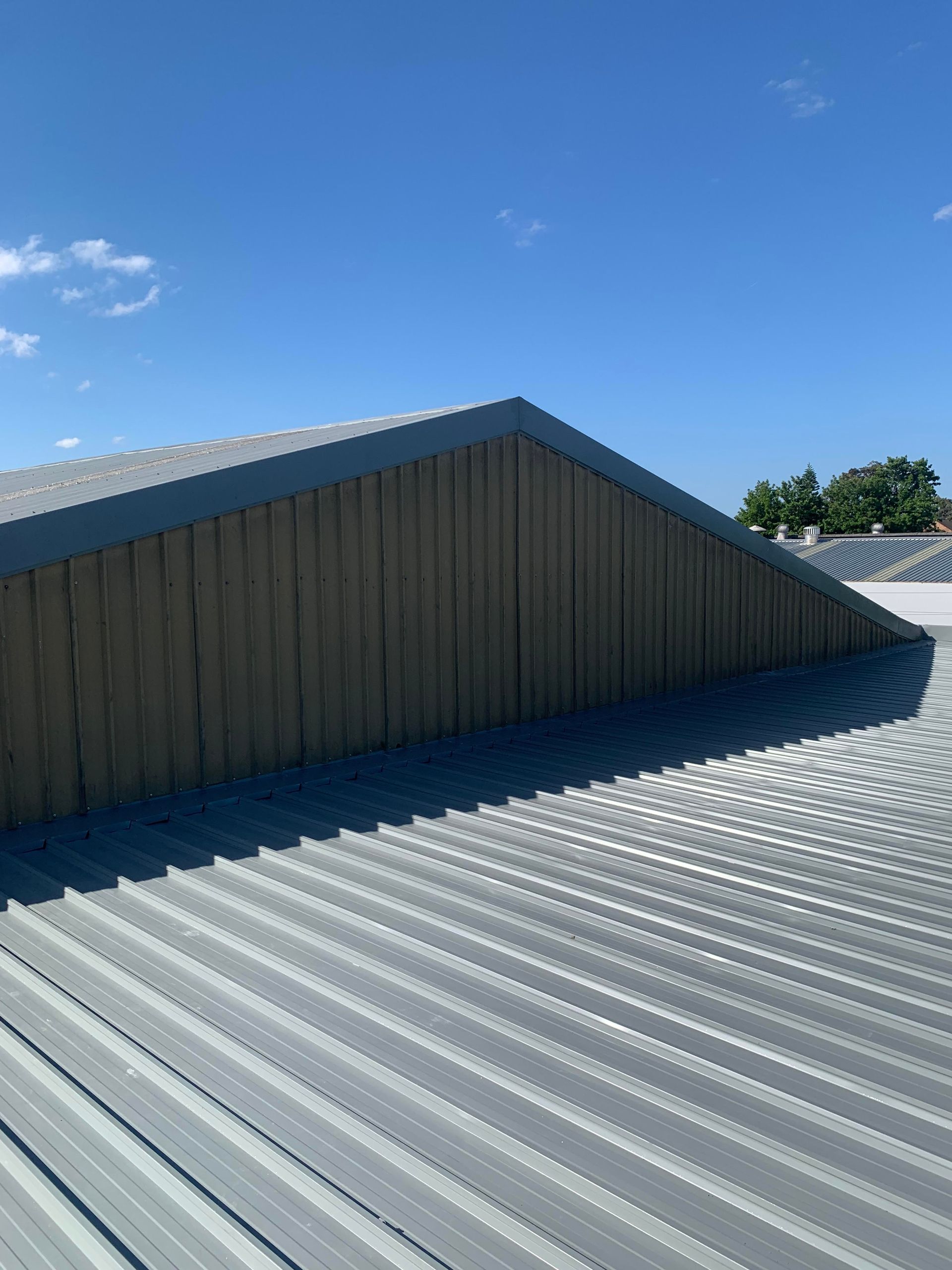 The roof of a building with a blue sky in the background — Kimick Roofing Solutions In Wyong, NSW