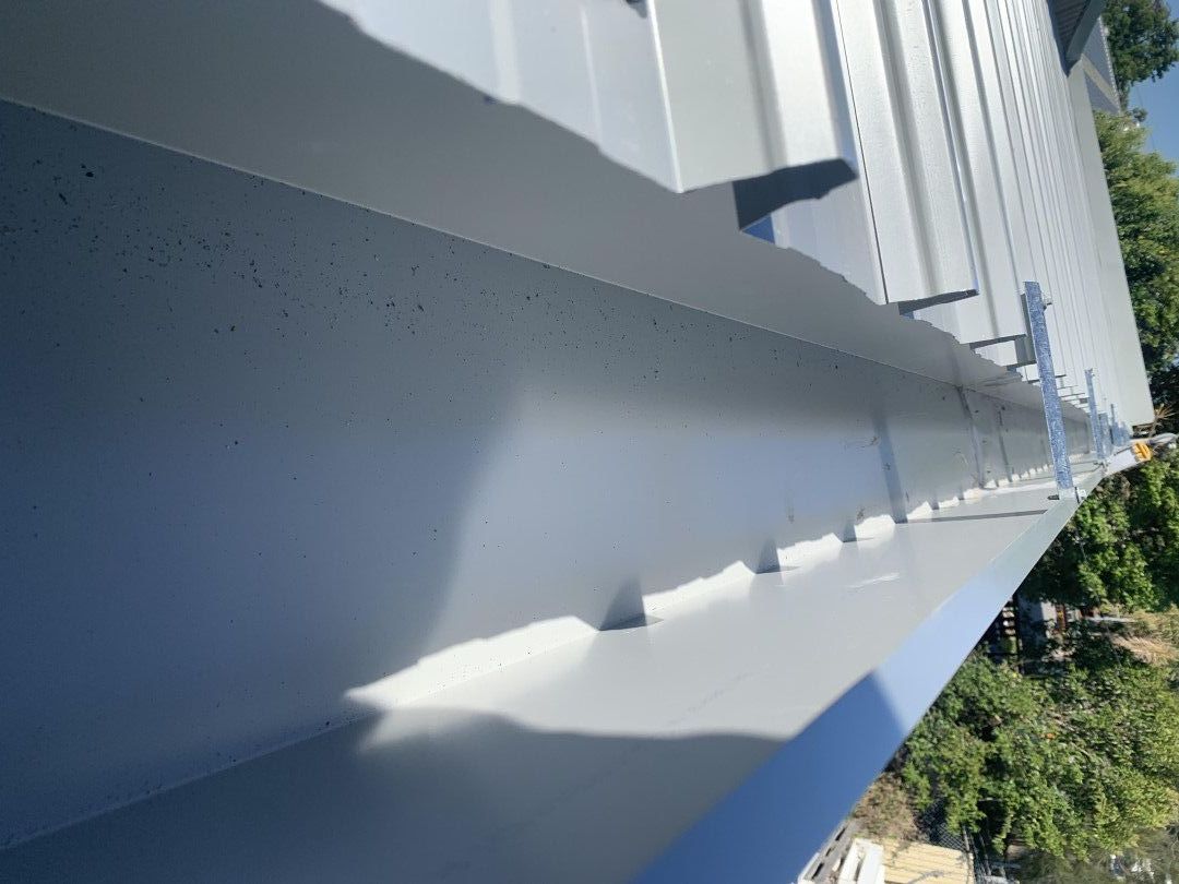 A white building with a gutter on the side of it — Kimick Roofing Solutions In Wyong, NSW