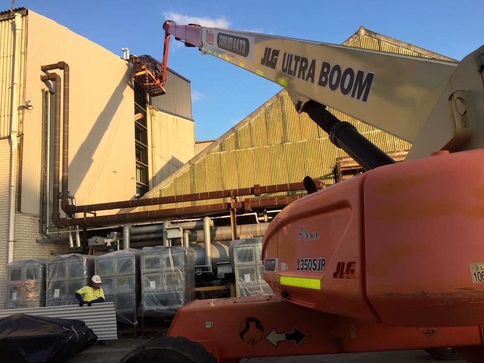 A Industrial Building With People In PPC Gear Removing Roofing — Kimick Roofing Solutions In Wyong, NSW