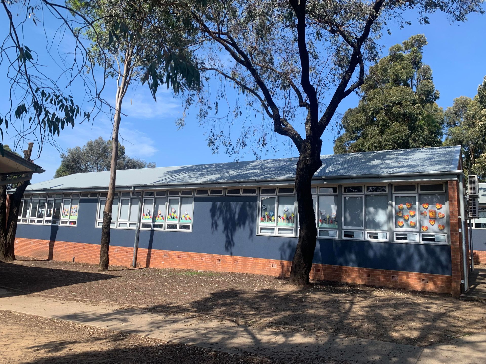 A large building with a lot of windows is surrounded by trees — Kimick Roofing Solutions In Wyong, NSW