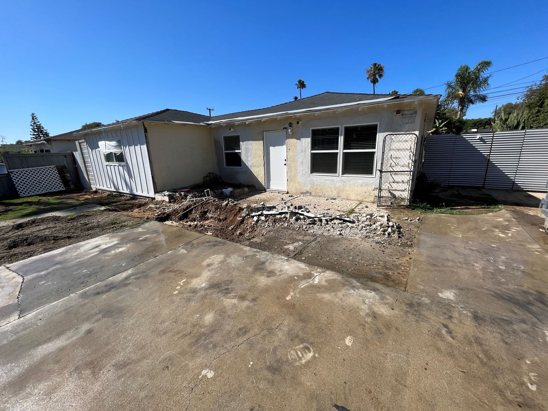 A house that is being demolished with a lot of dirt in front of it.