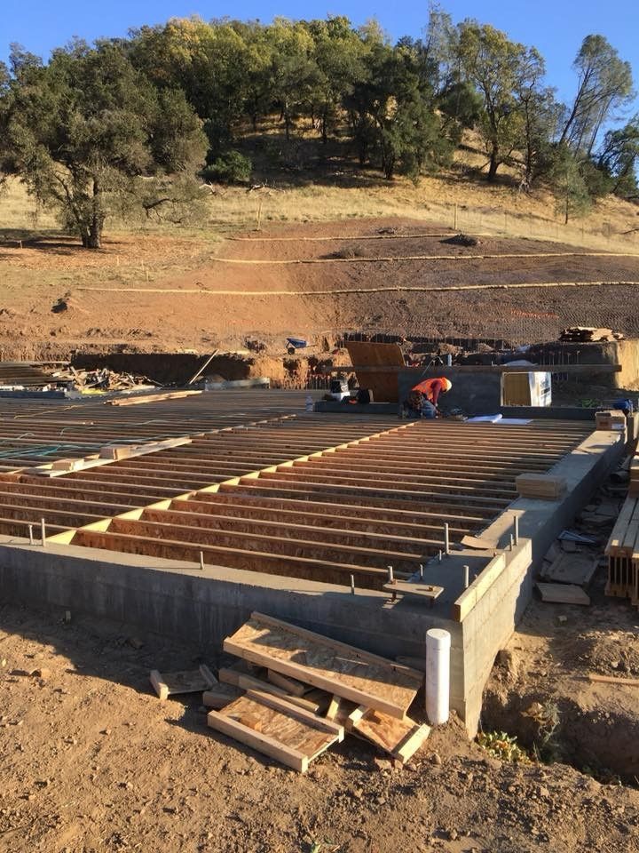 A man is working on the foundation of a house.