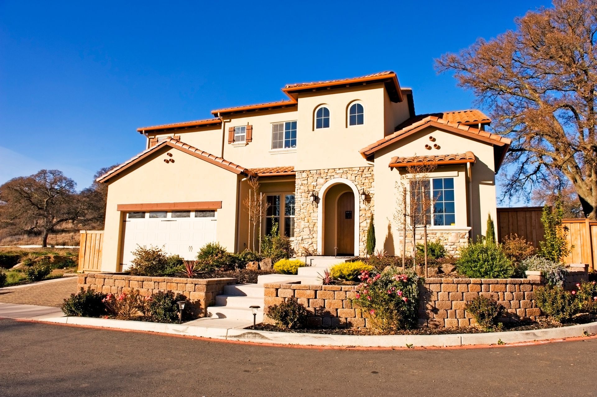 A large house with a white garage door is on a sunny day