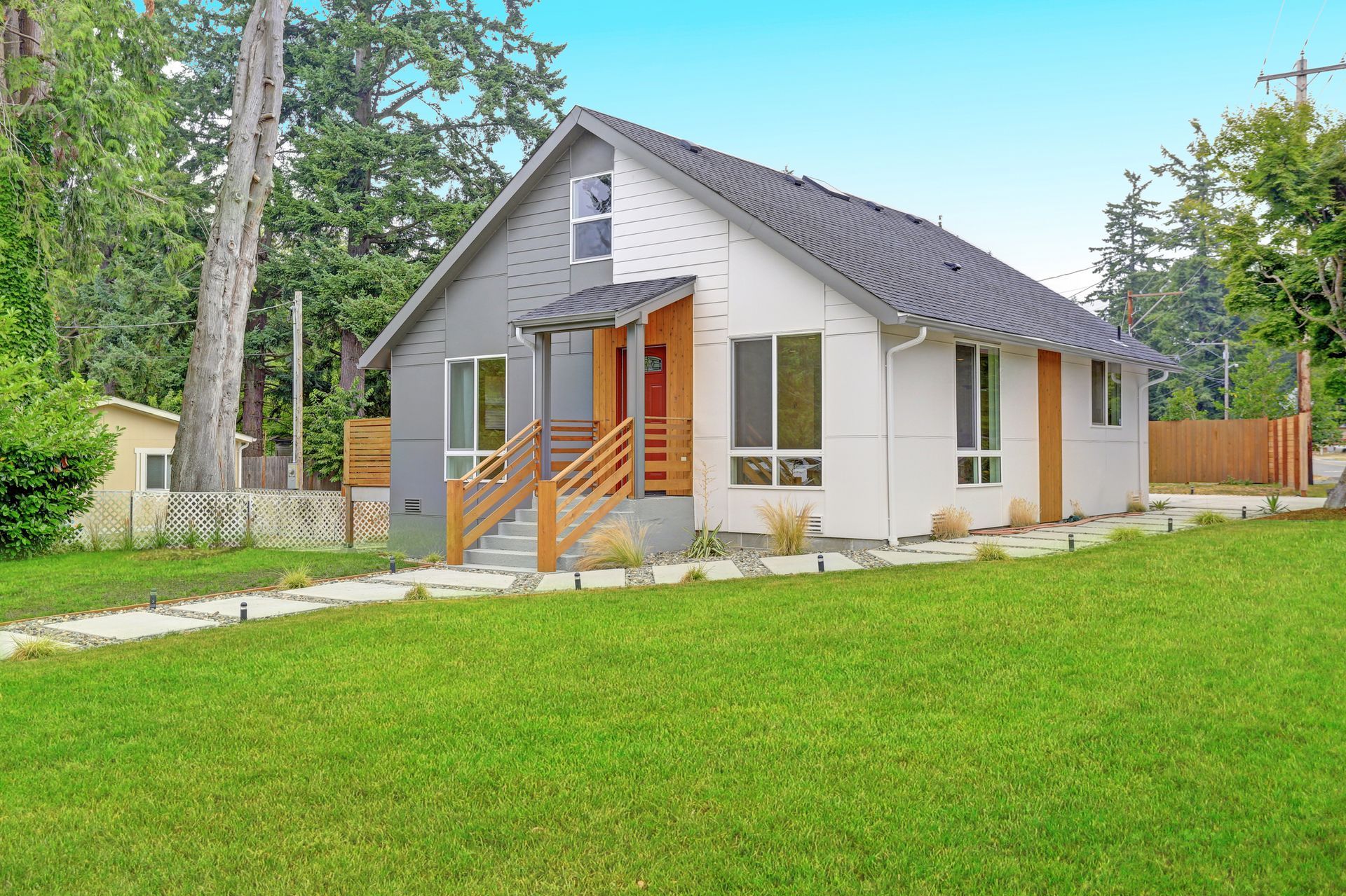 A small house with a lush green lawn in front of it.