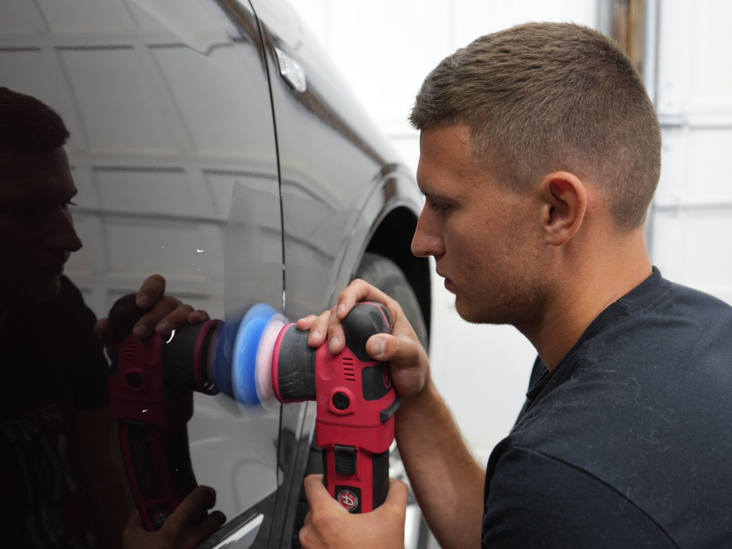 A man is polishing a car with a machine