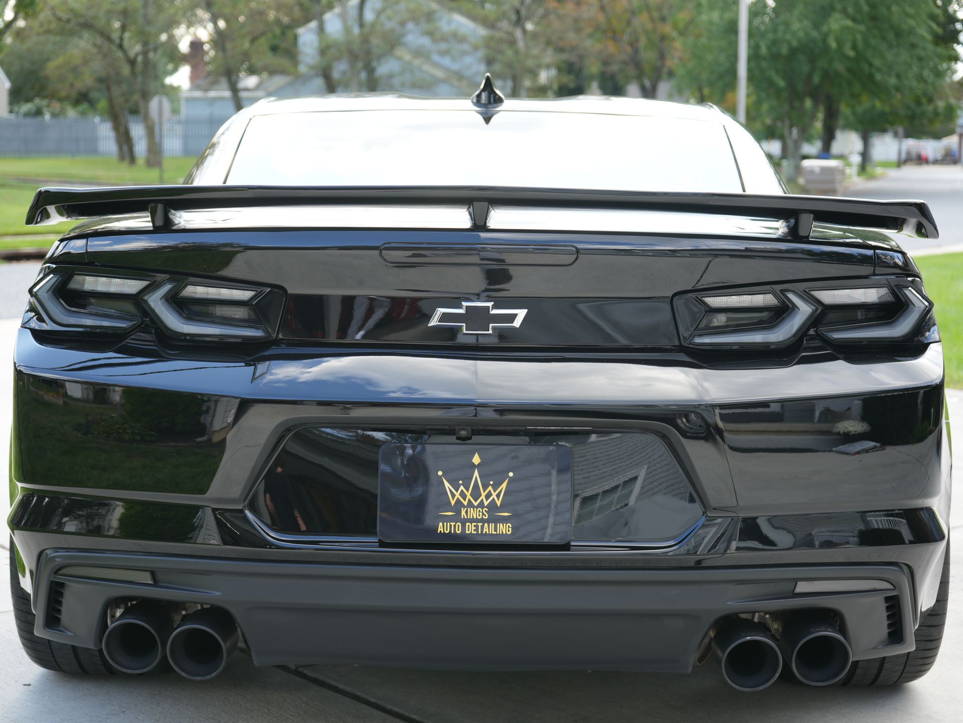a man wearing headphones is cleaning a car with a towel