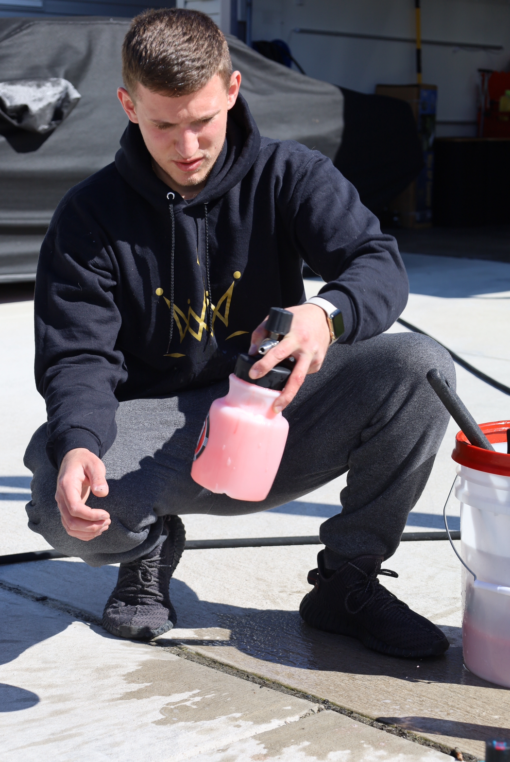 a man wearing a black hoodie with a crown on it