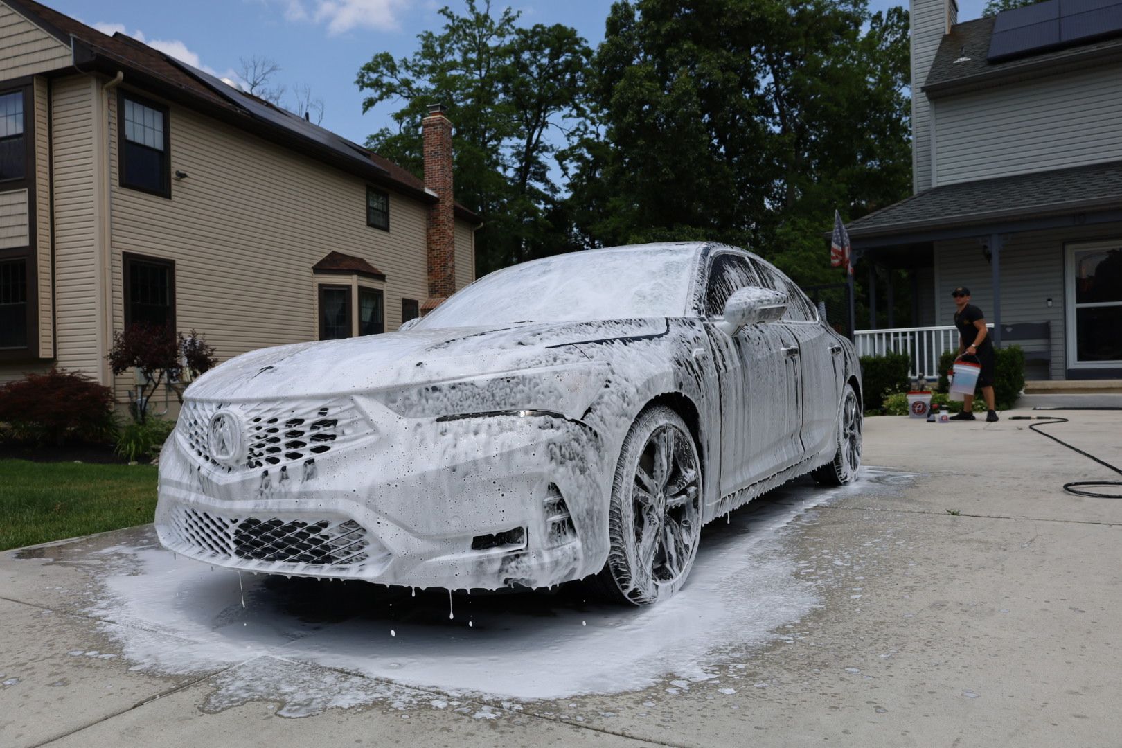 a car is covered in foam in front of a house