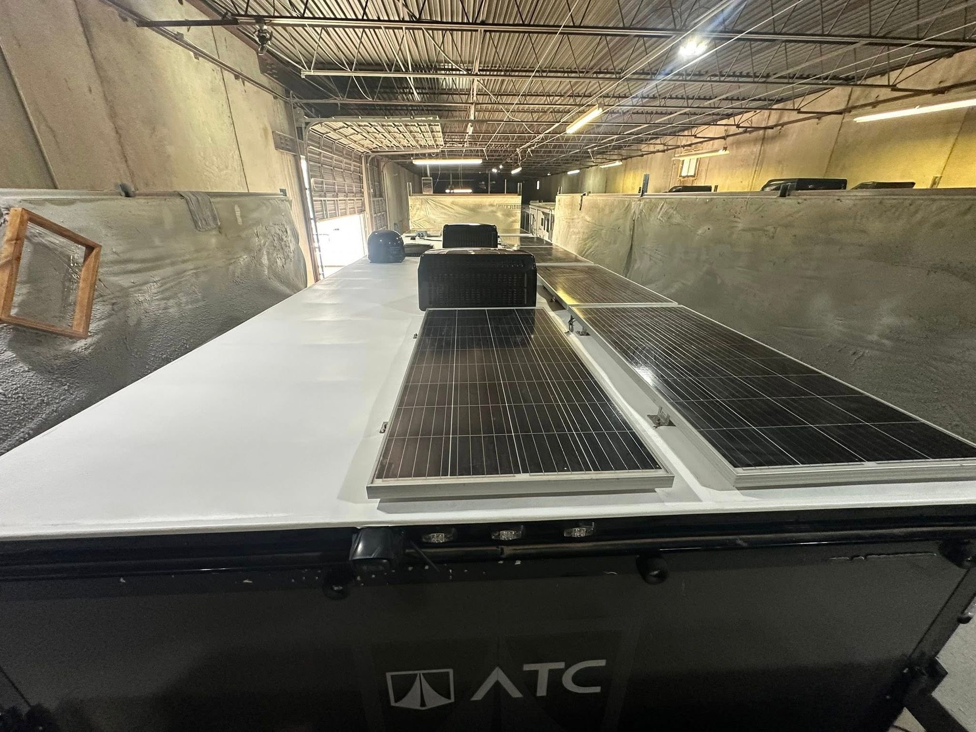 Solar panels on top of an ATC trailer in an industrial setting.