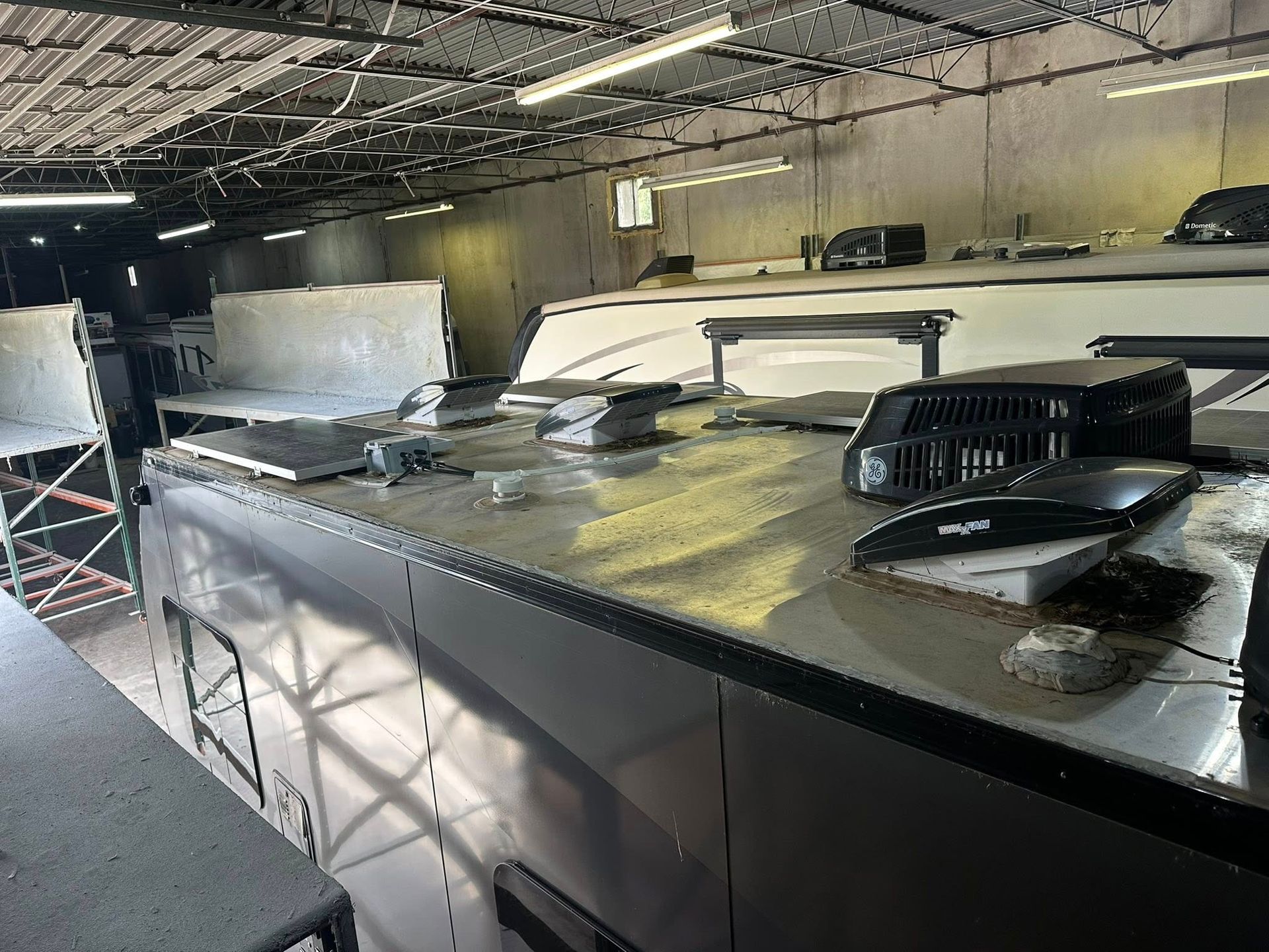 RV roofs inside a warehouse, showing vents, skylights, and other roof features.