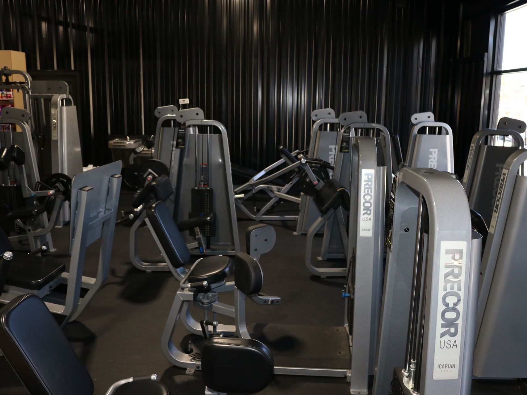 A row of dumbbells are lined up in a gym.