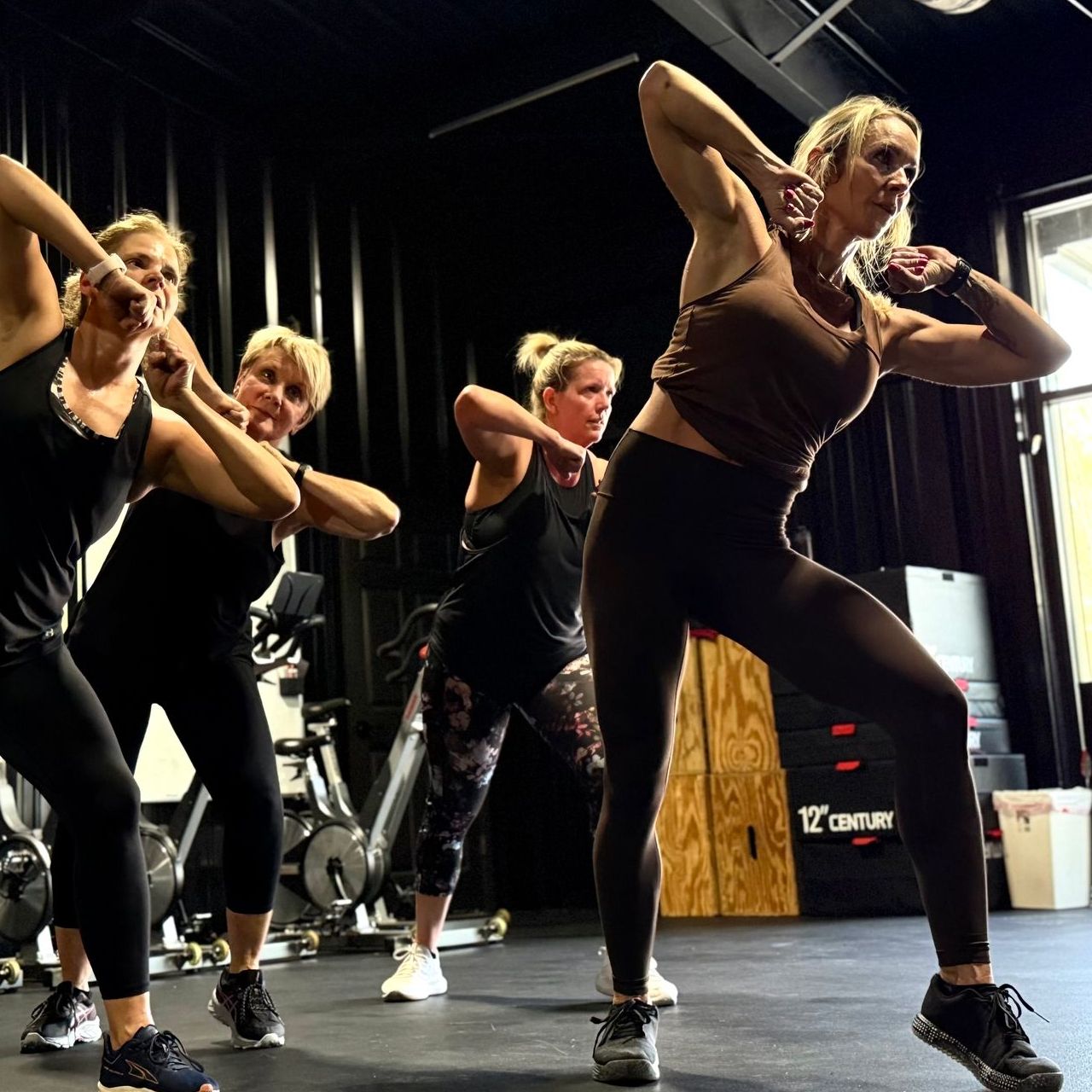 A group of women are dancing together in a gym