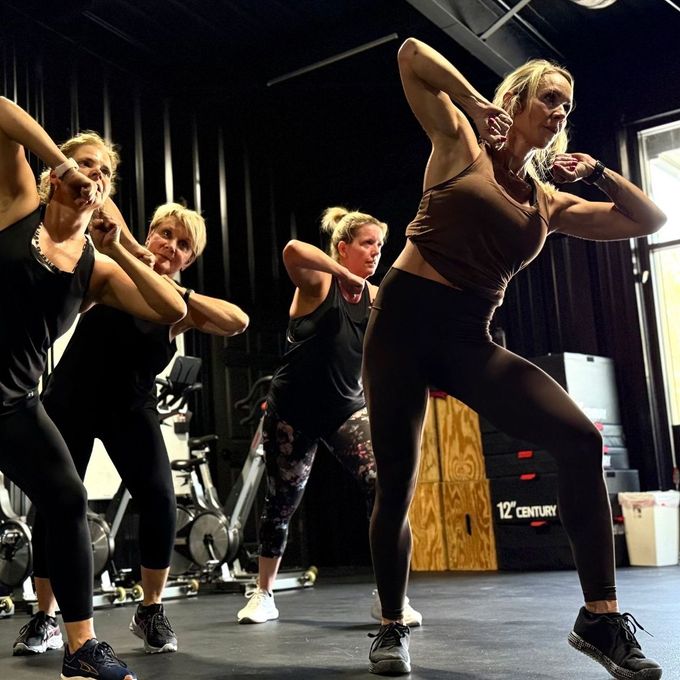 A group of women are dancing together in a gym