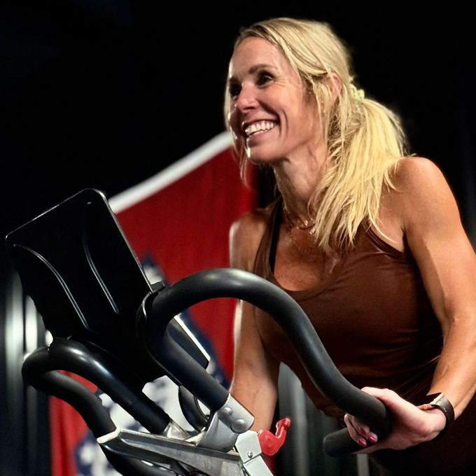 A woman is riding an exercise bike in a gym