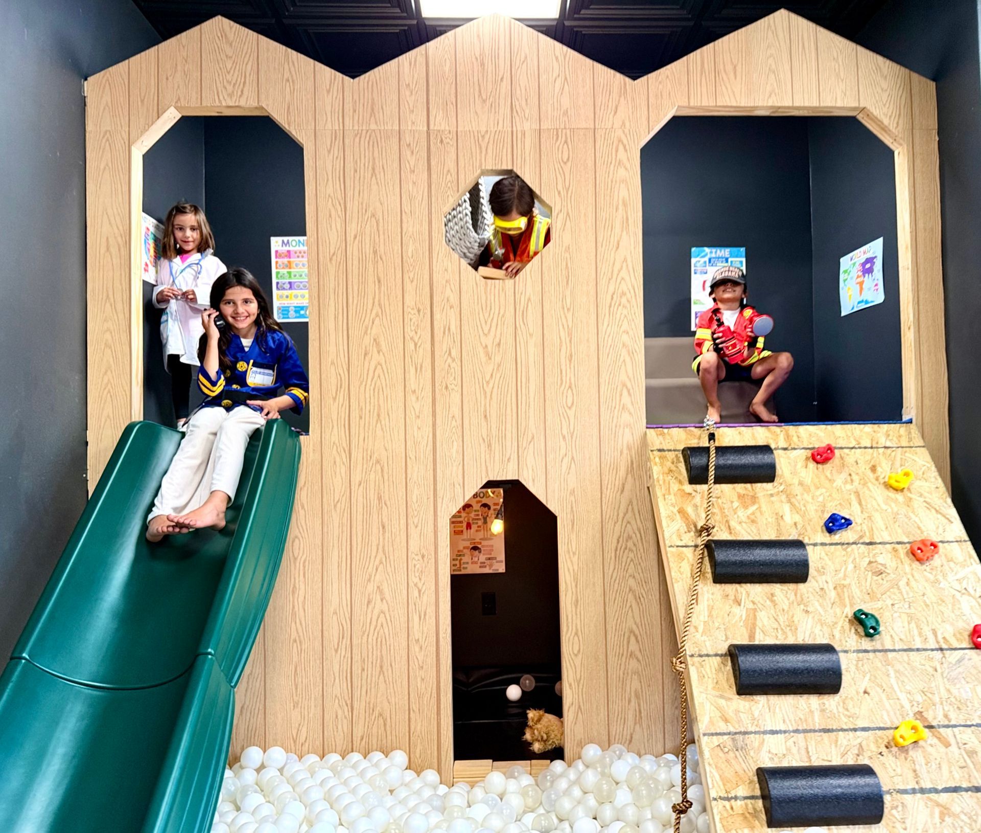 A woman and two children are playing on a slide in a playground.