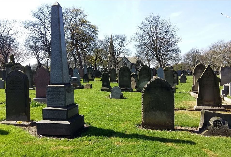 A cemetery with lots of graves and trees