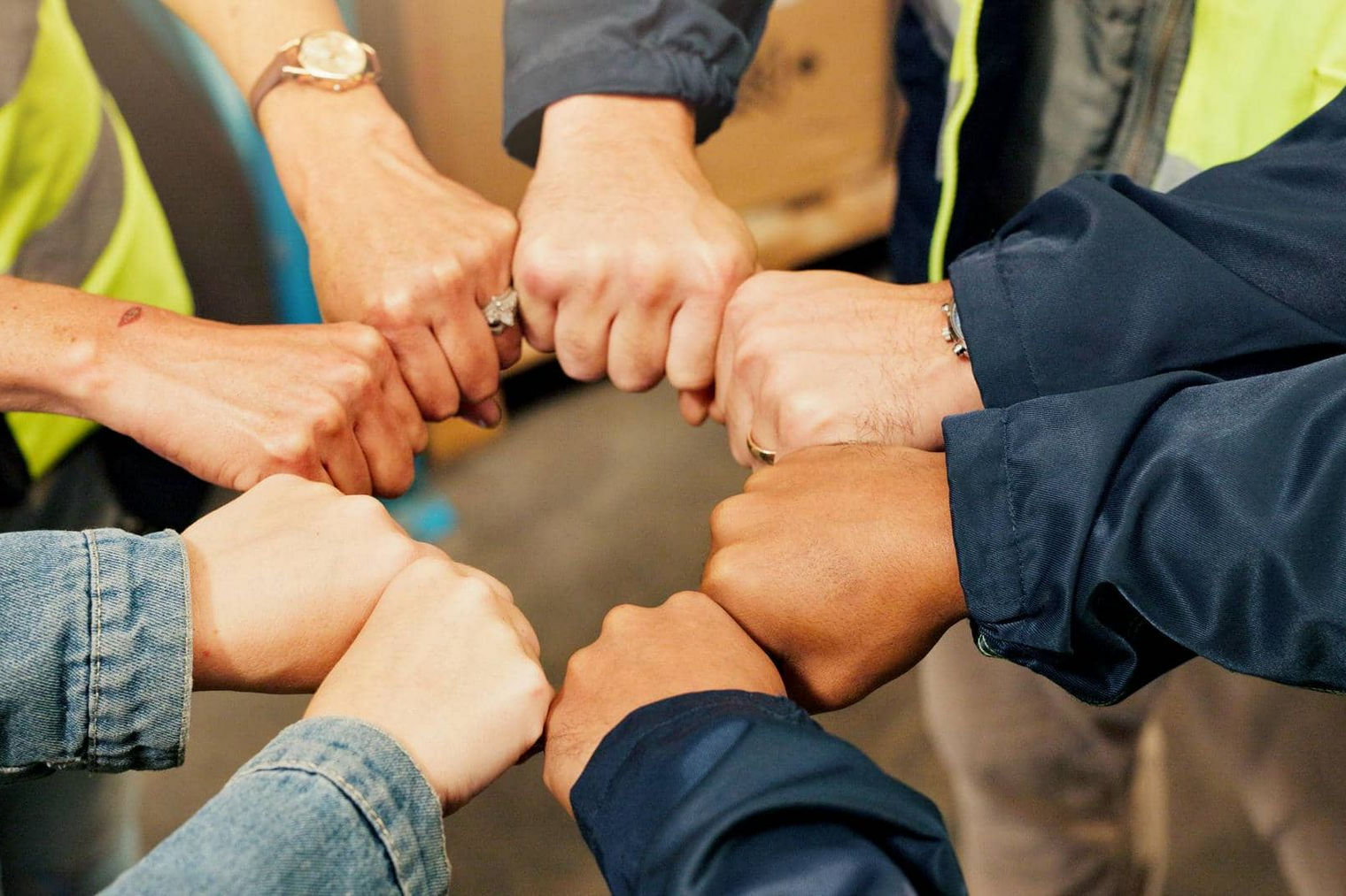 Hands in a circle, fists bumping together in a sign of teamwork or solidarity.