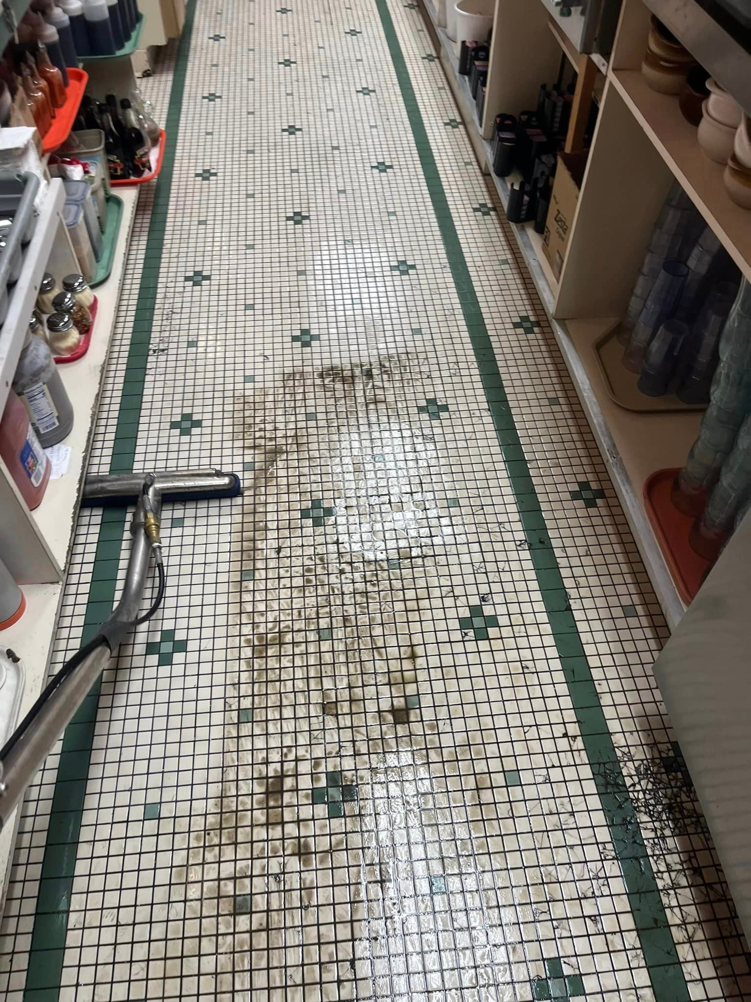 A vacuum cleaner is cleaning a tiled floor in a store.
