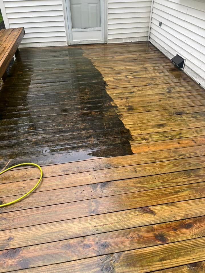 A wooden deck is being cleaned with a pressure washer.