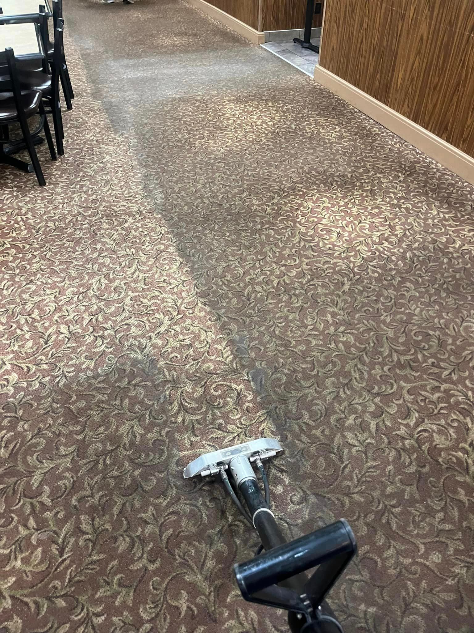 A vacuum cleaner is sitting on a carpeted floor in a room.