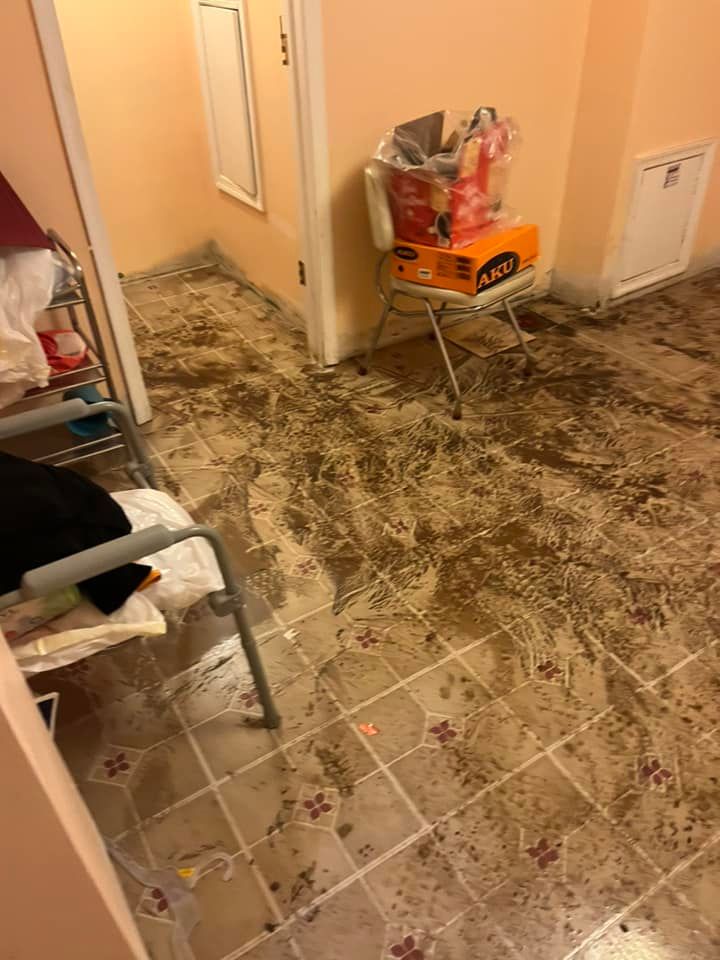 A room with a lot of dirt on the floor and a chair.