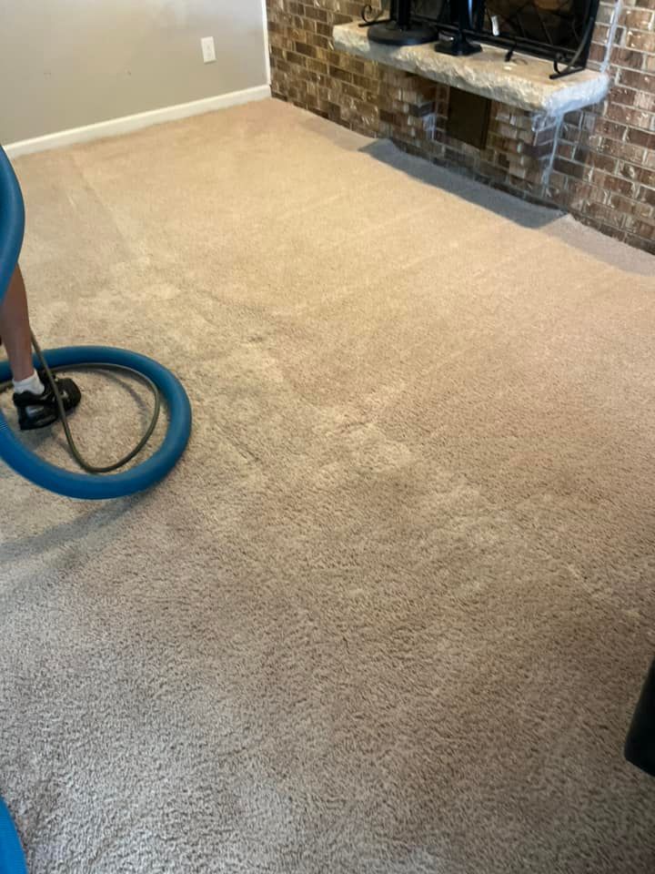 A person is using a vacuum cleaner to clean a carpet in a living room.