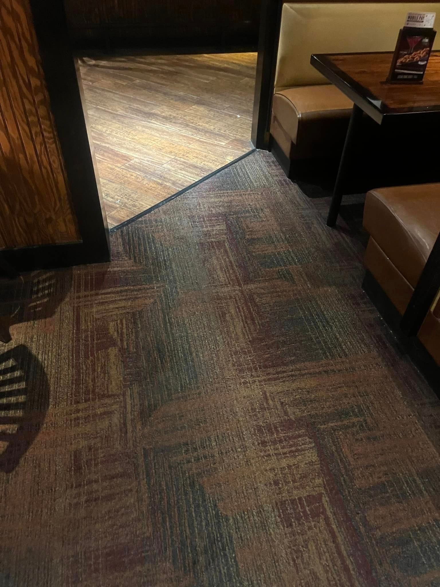 A restaurant with a table and chairs and a carpeted floor.