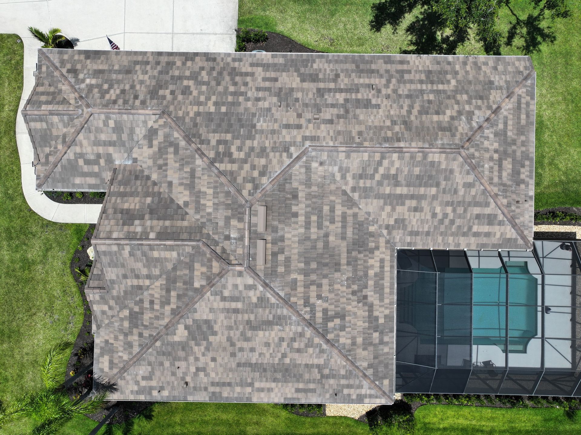 An aerial view of a house with a roof and a pool.