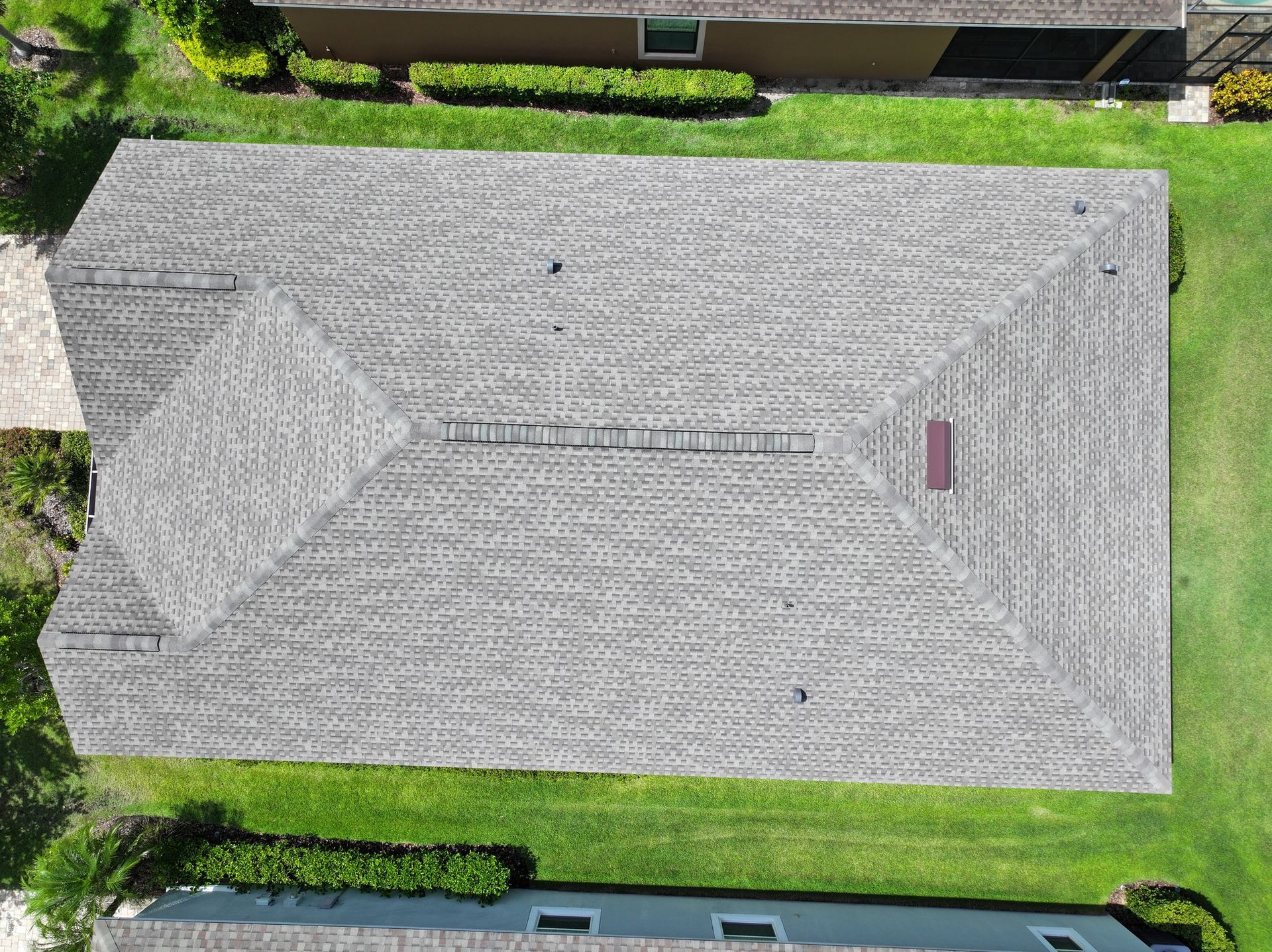 An aerial view of a house with a roof that is covered in shingles.