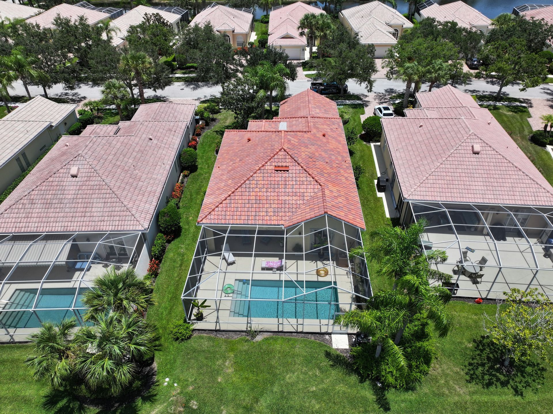 An aerial view of a house with a pool in a residential area.