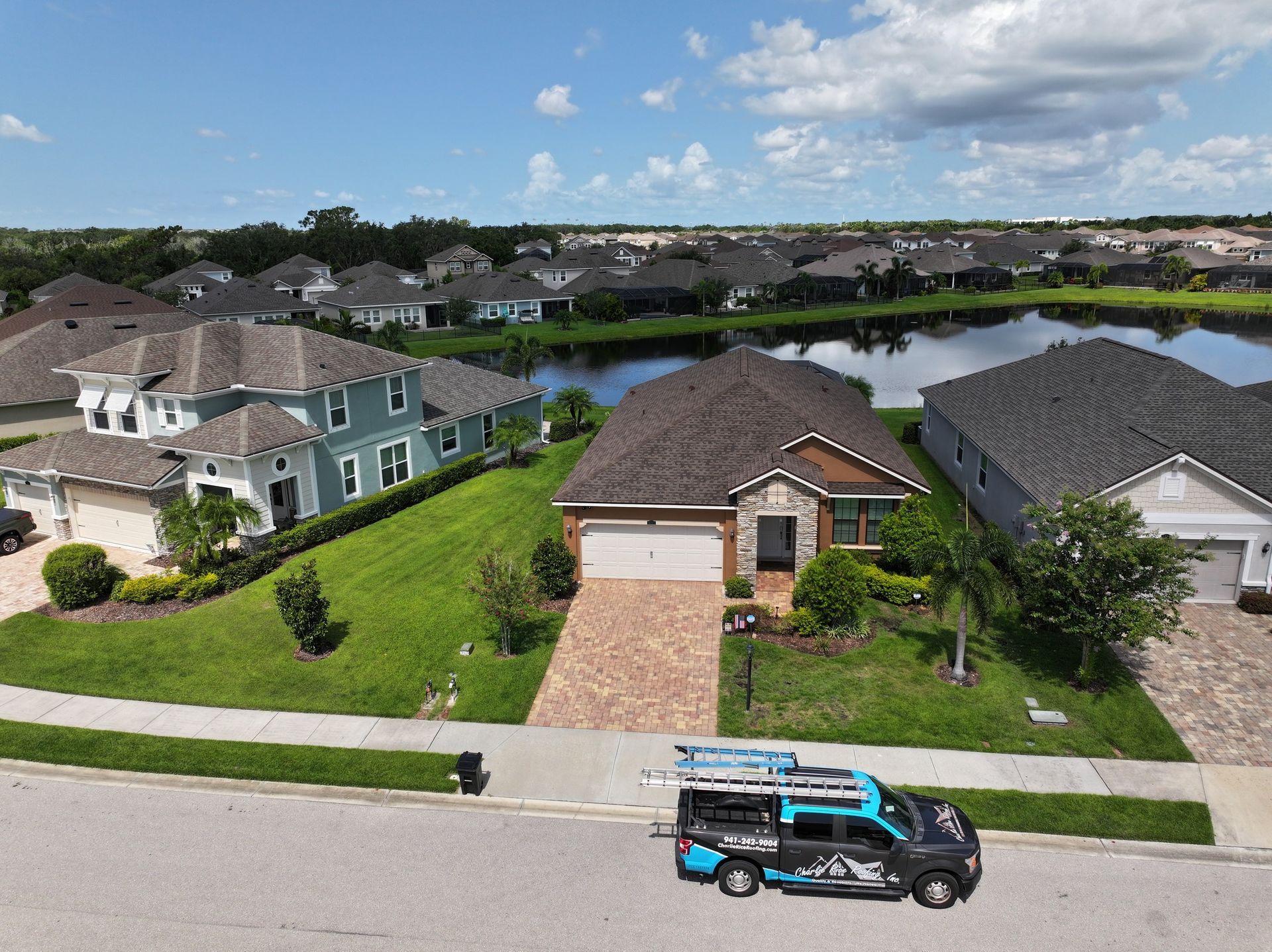 An aerial view of a residential neighborhood with a van parked in front of a house.