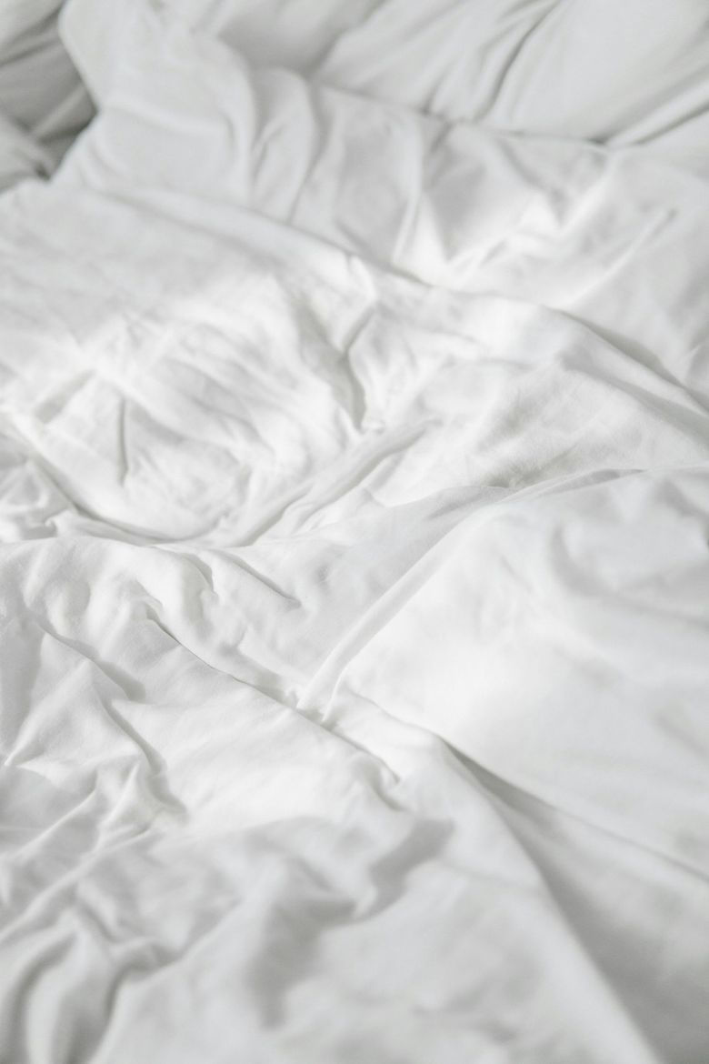 White, rumpled bedsheets, sunlight catching the folds.