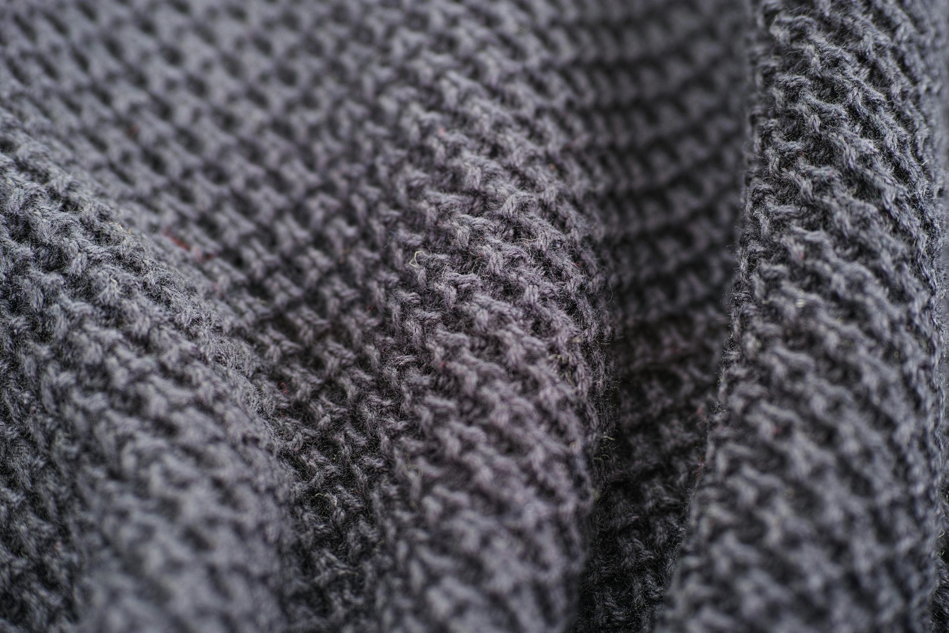 Close-up of gray knitted fabric with a textured, ridged pattern.