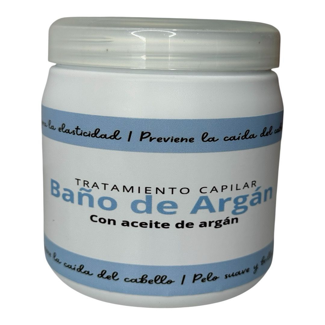 Tarro blanco de tratamiento capilar “Baño de Argán”, con etiqueta azul y blanca y texto en español.