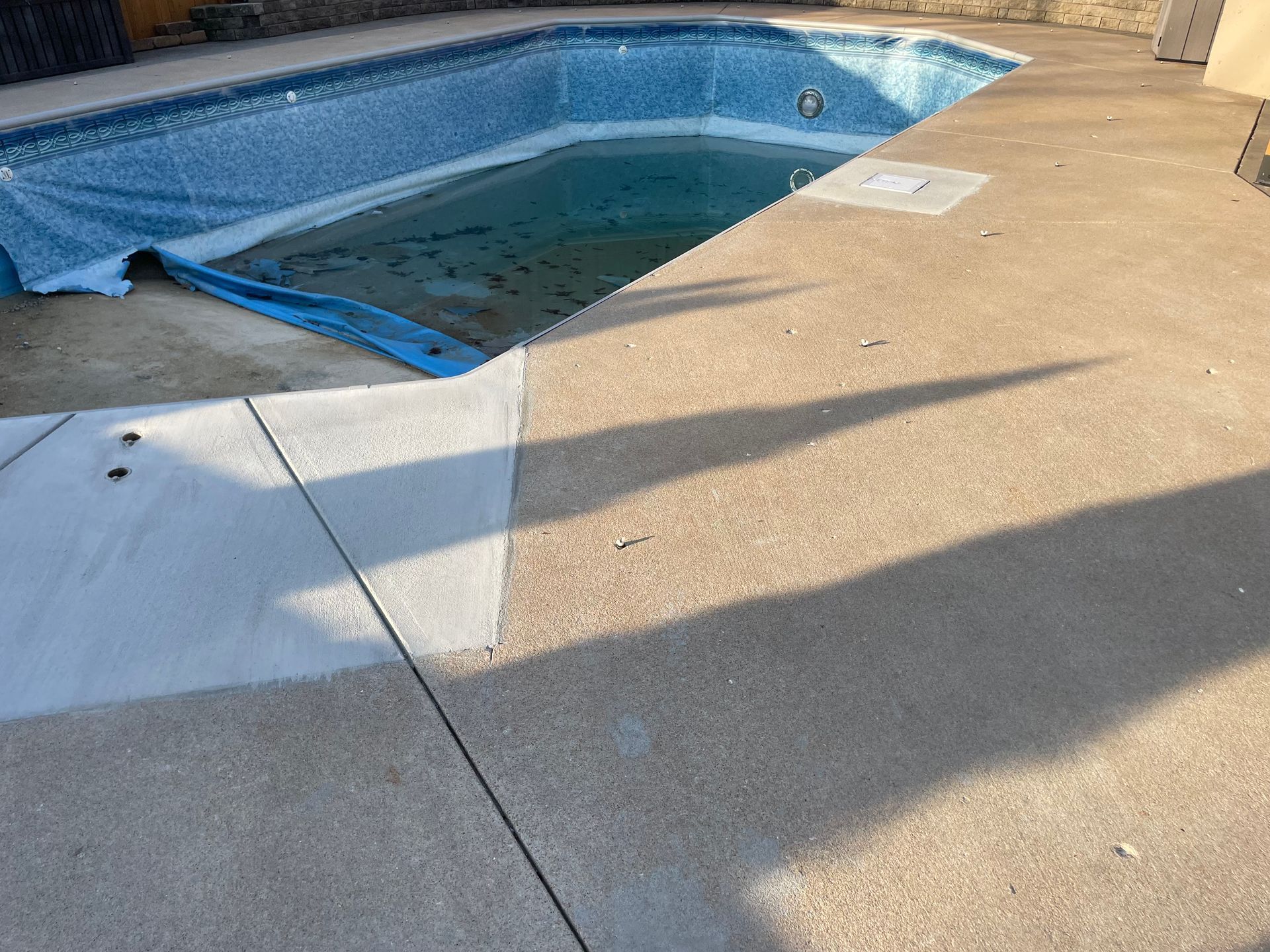 Ground and resurfaced chipped epoxy finish around a pool. Custom Concrete solution
