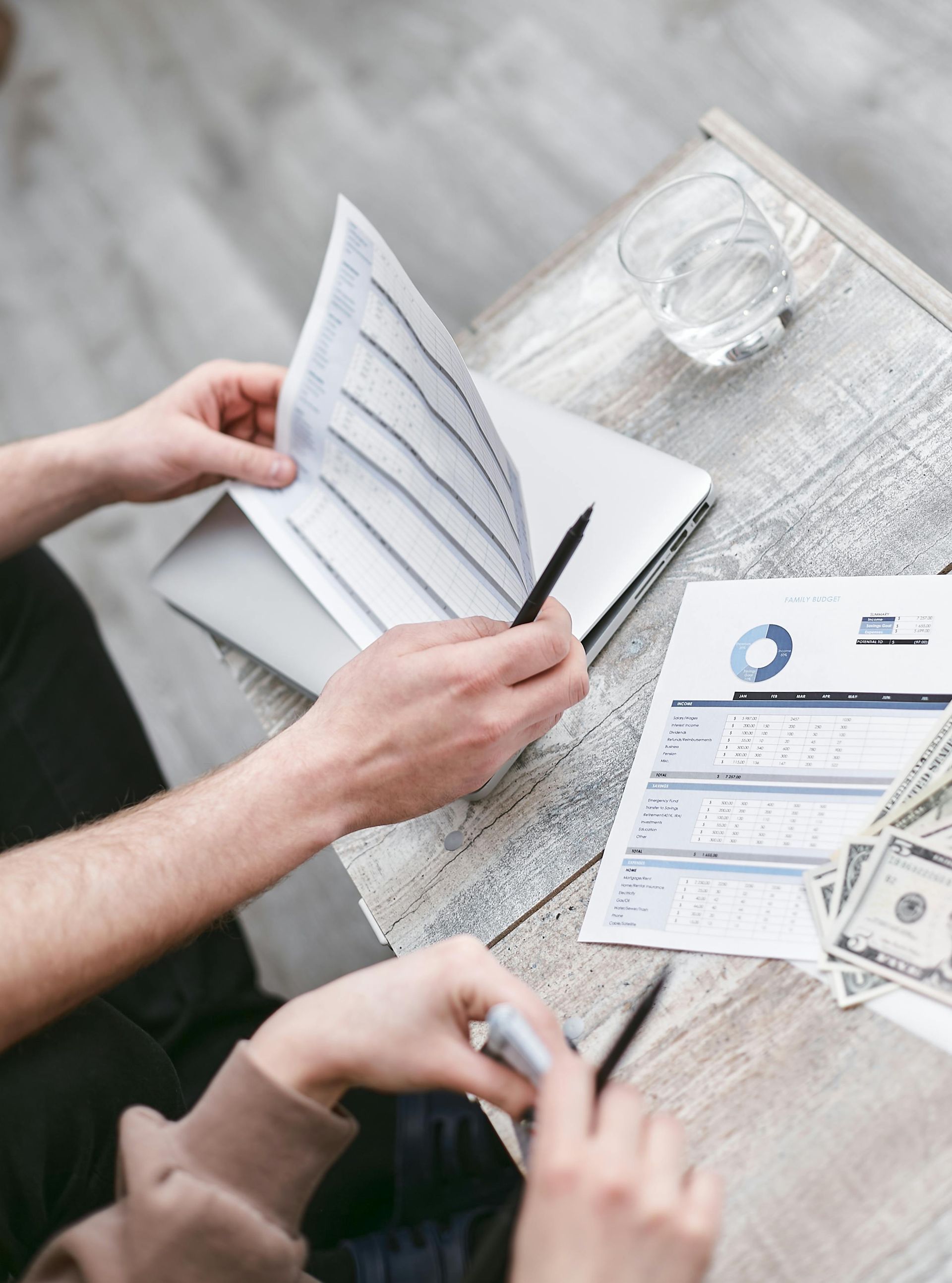 A man and a woman are sitting at a table looking at papers.