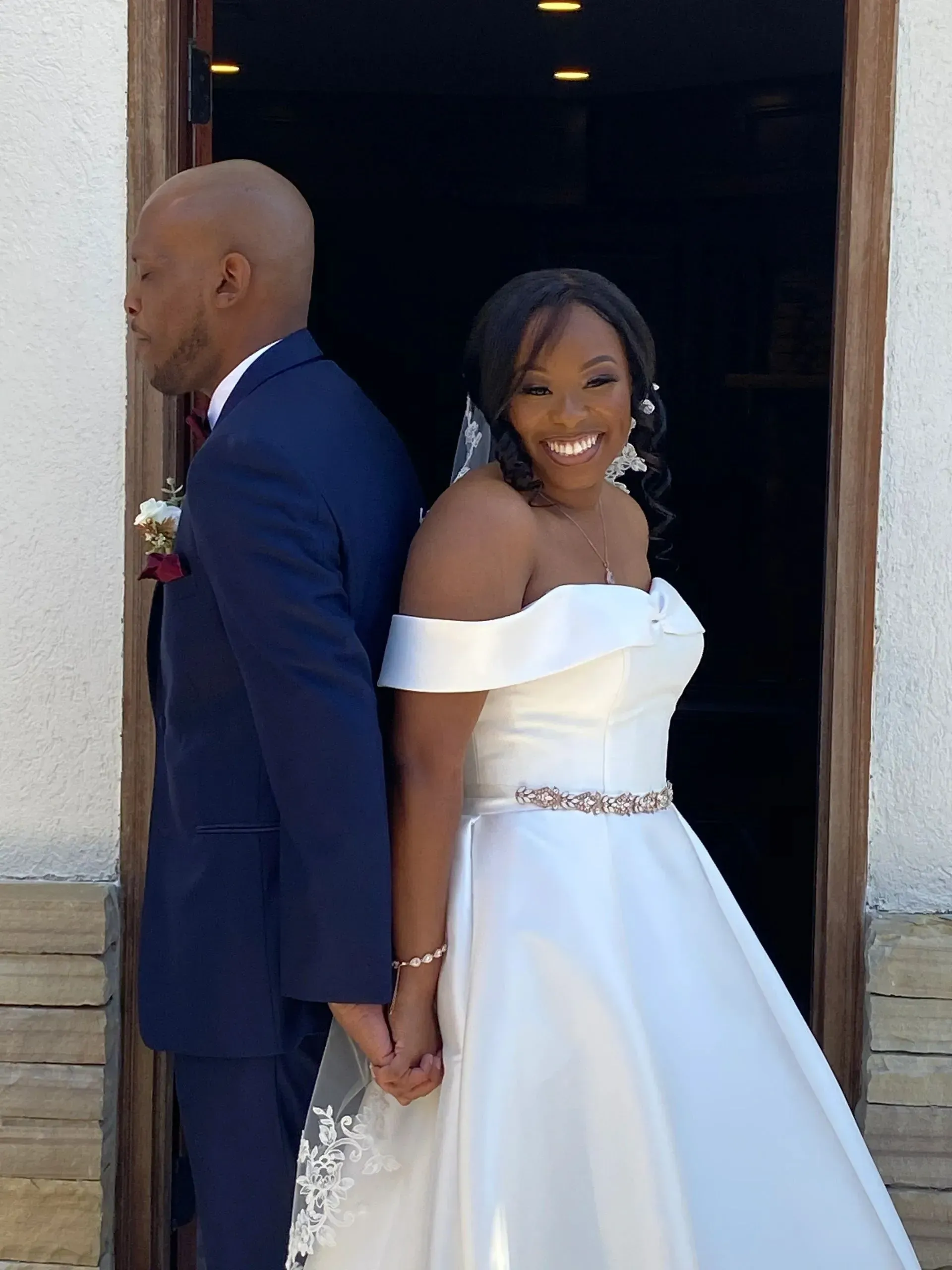 A bride and groom standing next to each other holding hands