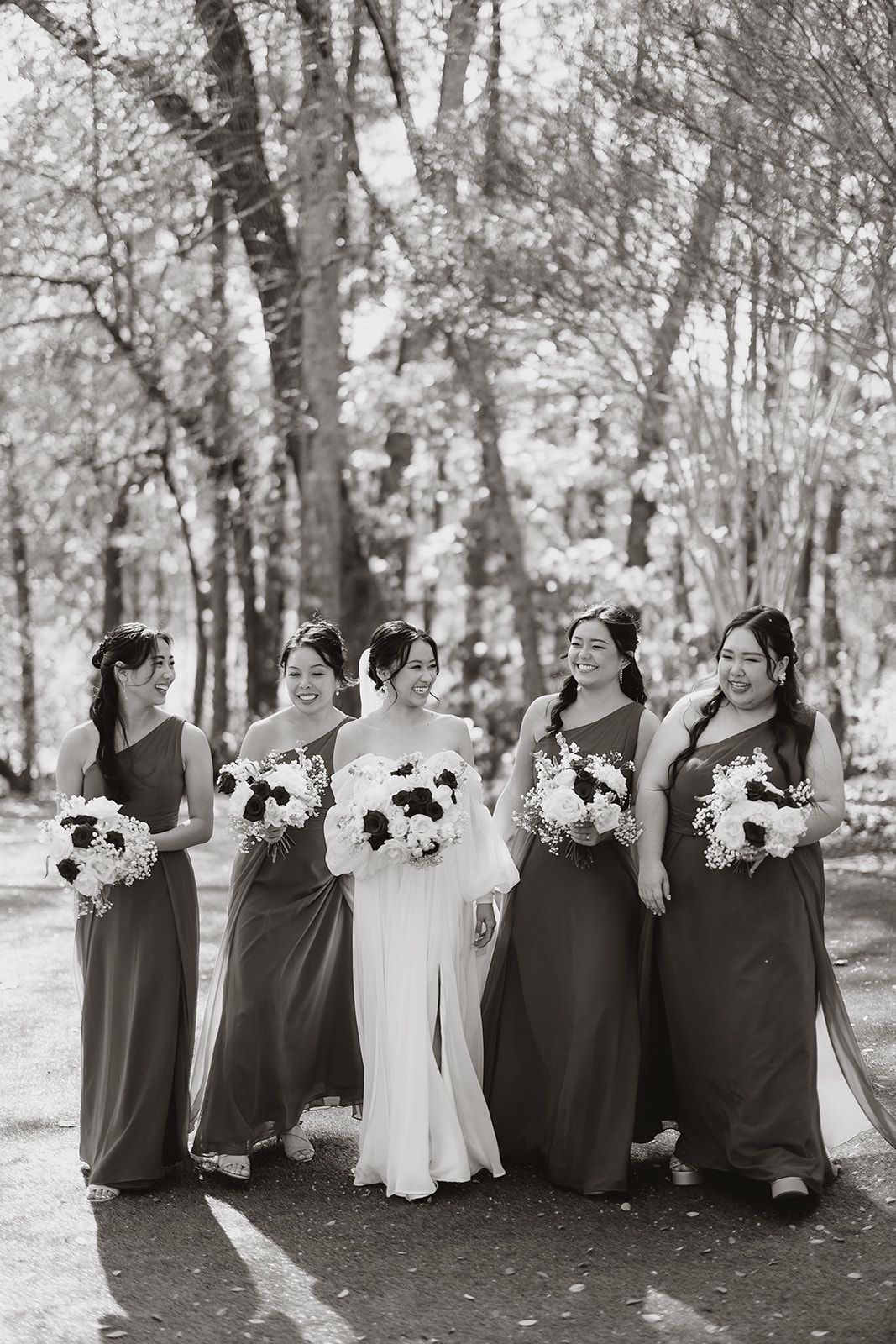 A bride and her bridesmaids are posing for a black and white photo.