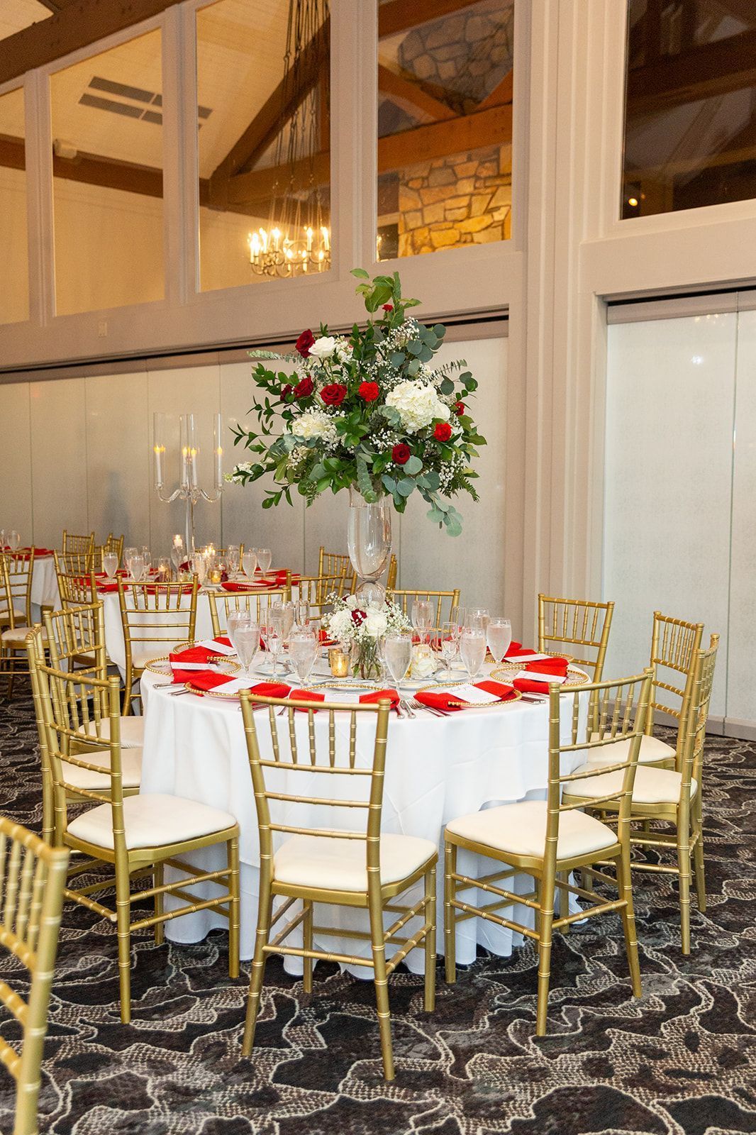 A large room with tables and chairs set up for a wedding reception.