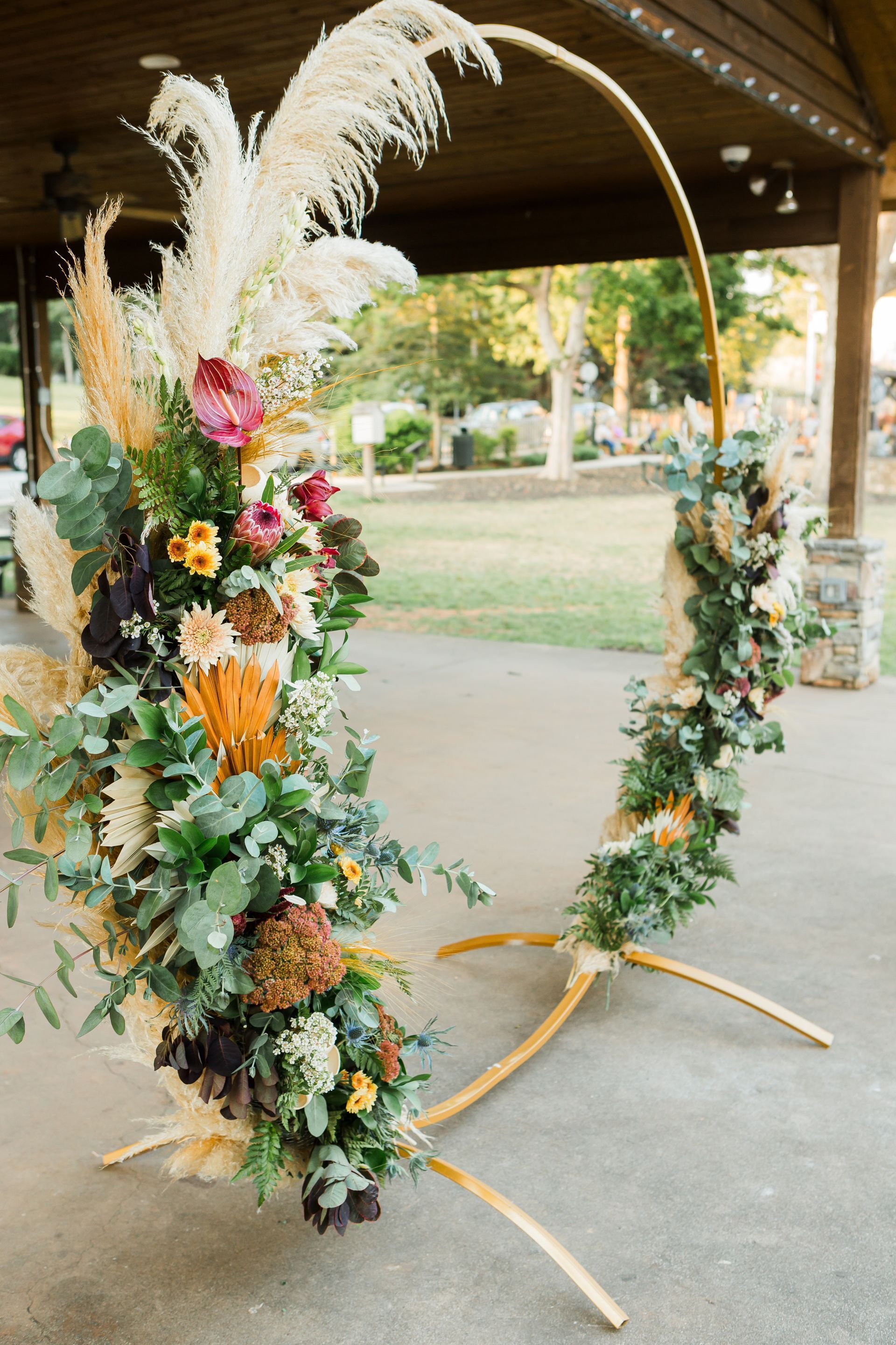 A large floral arch is sitting on the ground in front of a building.