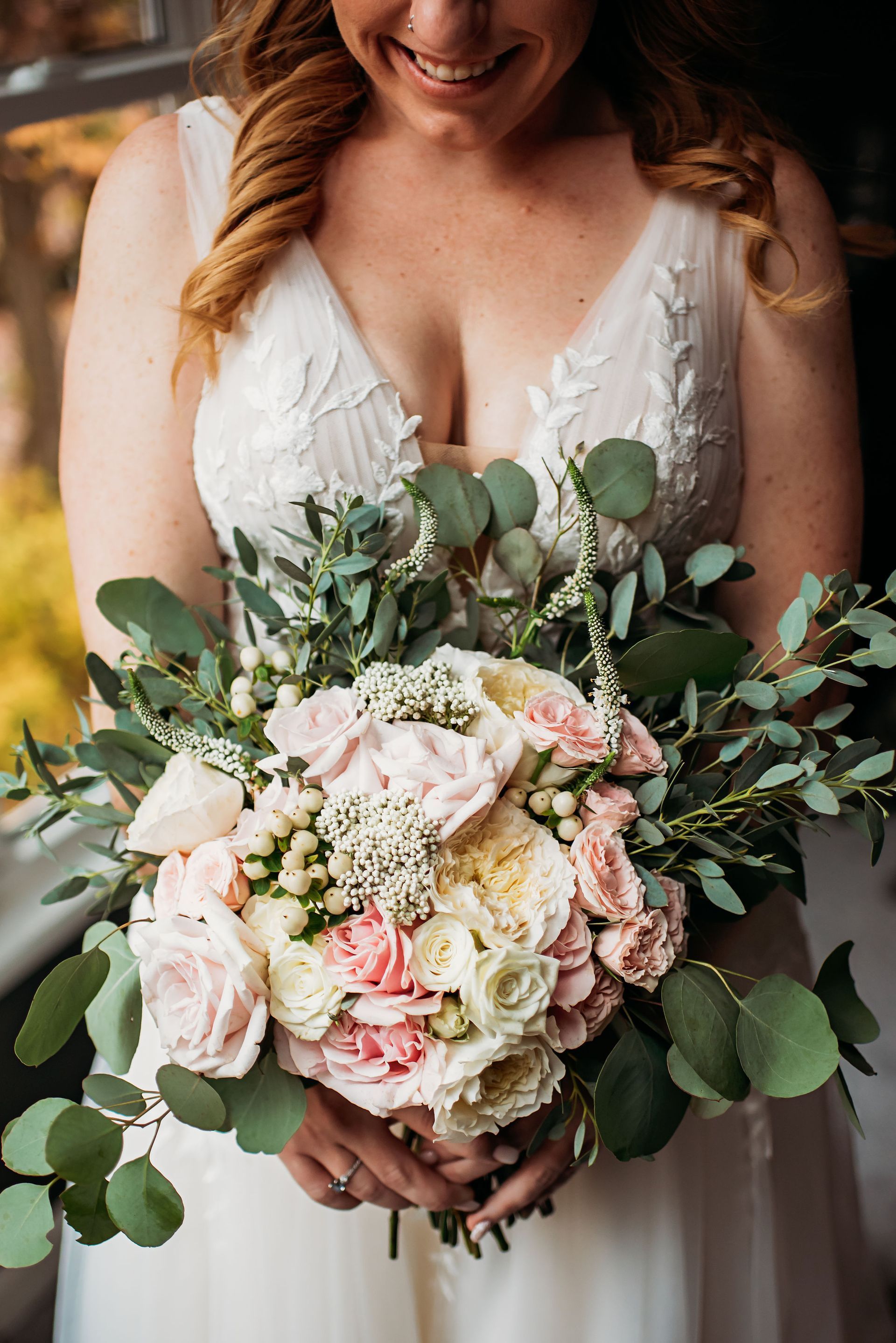 A bride in a white dress is holding a bouquet of flowers.