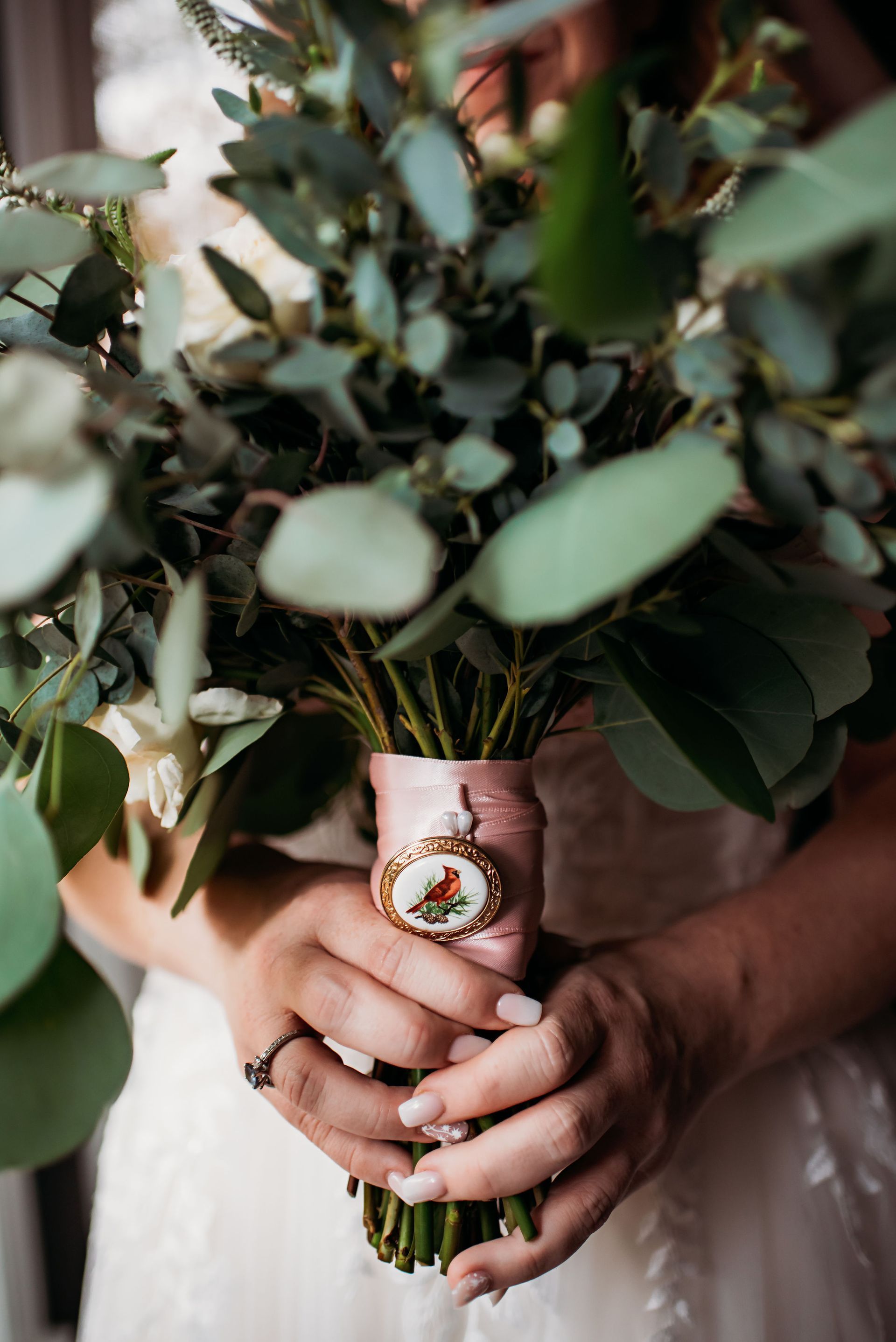 A bride is holding a bouquet of flowers in her hands.