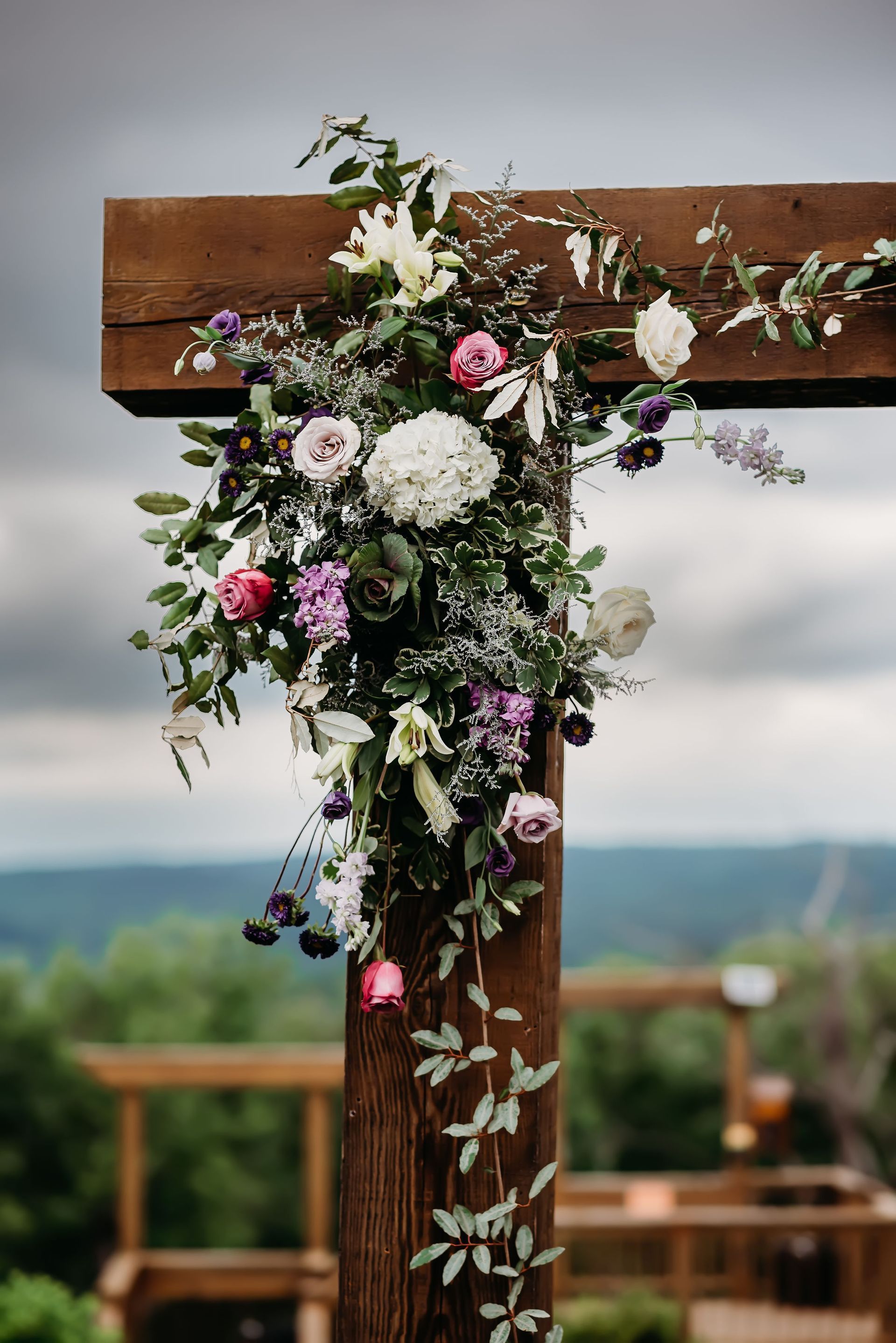 A wooden arch decorated with flowers and greenery for a wedding ceremony.