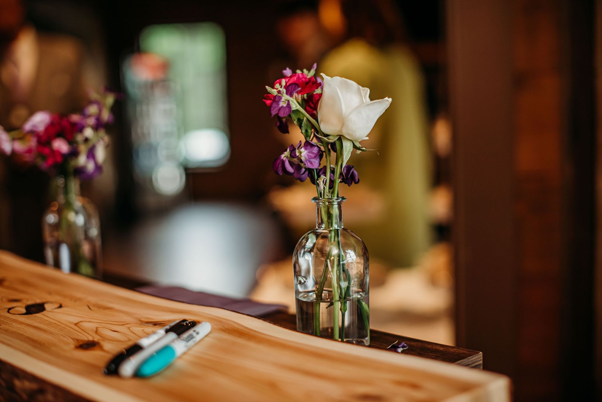 Two vases filled with flowers are sitting on a wooden table.