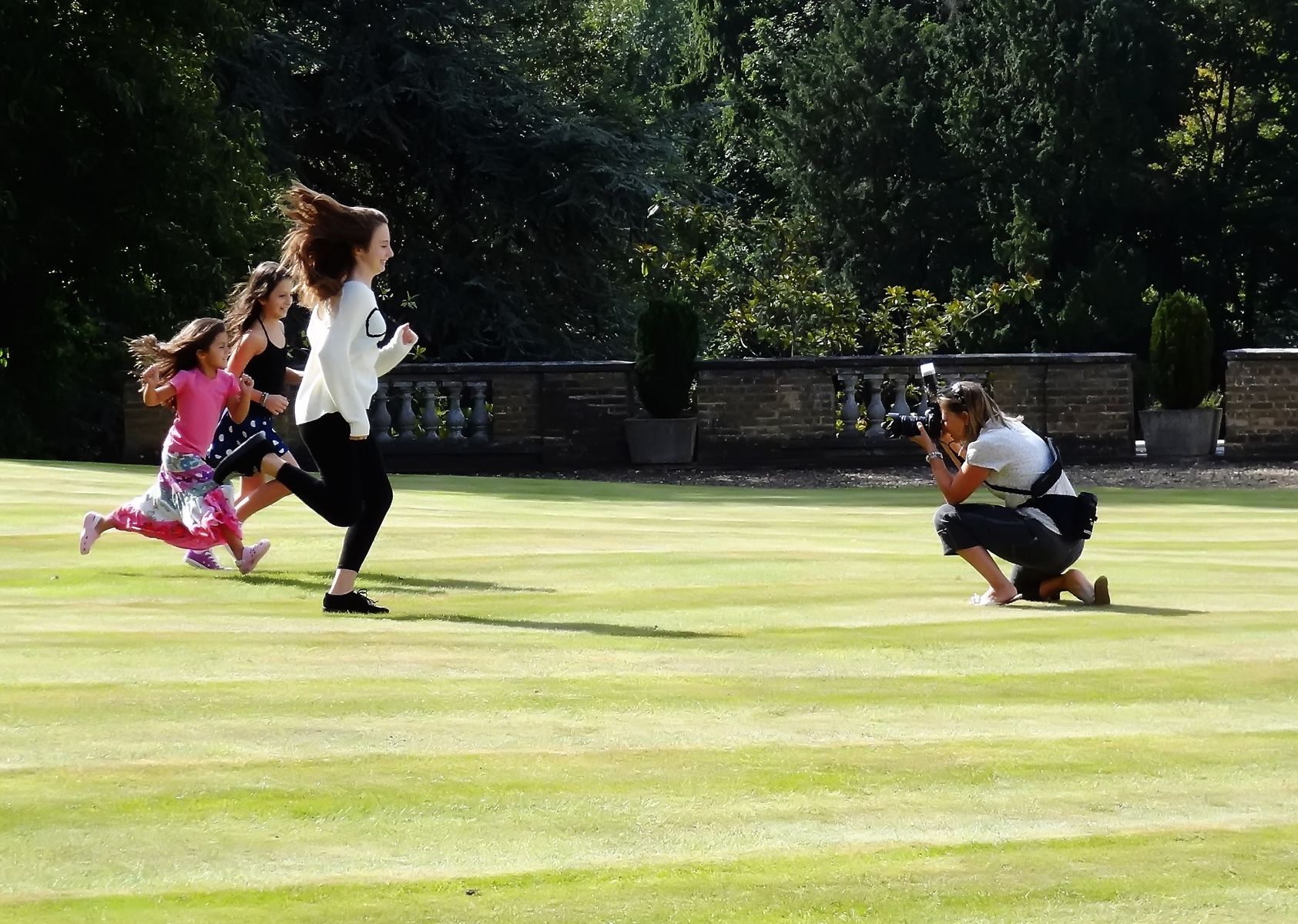 Professional photographer Berkshire, family photographer in action with children running towards her