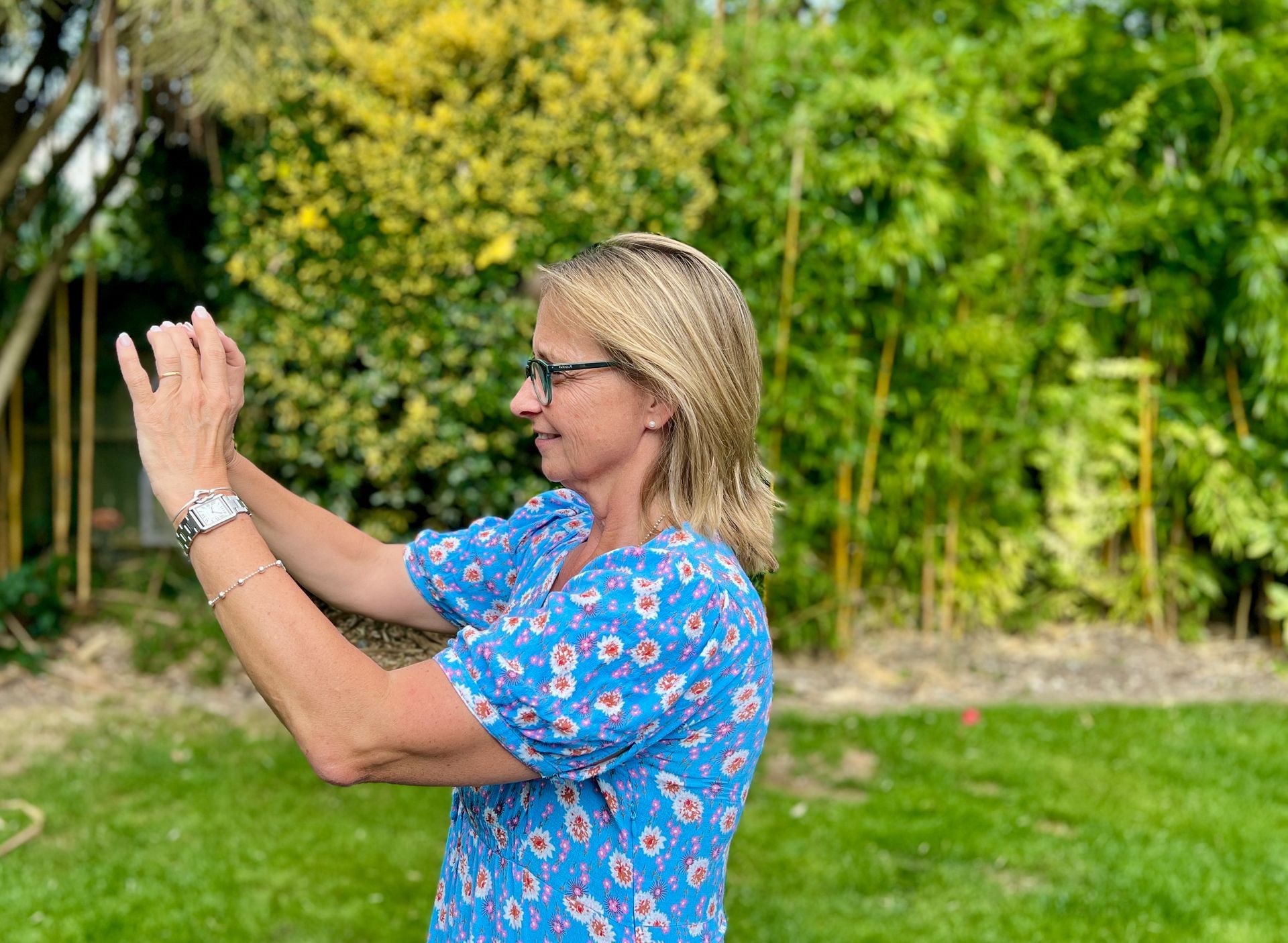 Commercial photography Reading, female taking photos on an iphone in garden