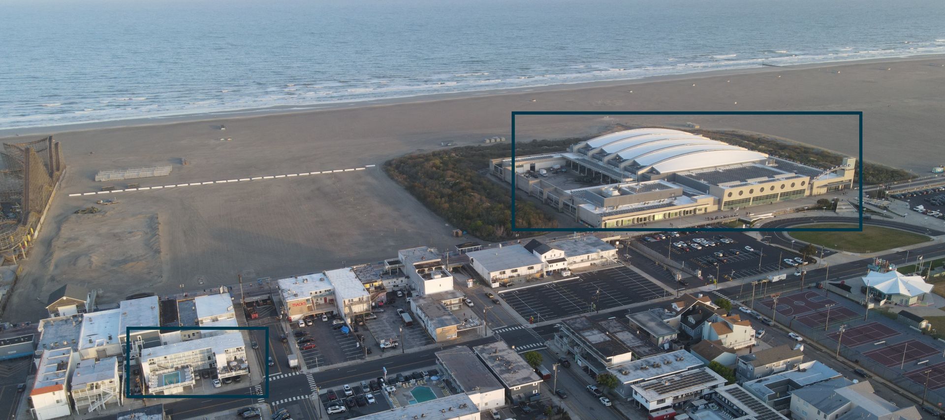 An aerial view of a beach with a large building in the middle of it.